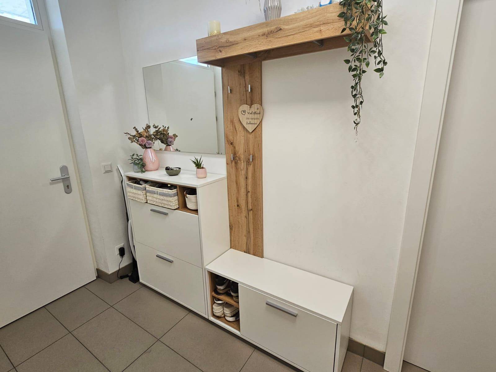 Detailansicht der modernen Garderobe mit Spiegel und integrierter Sitzbank im Flur.