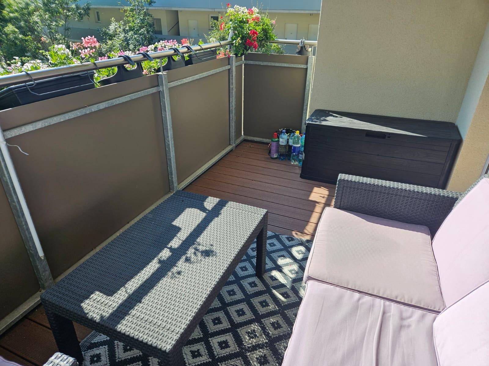 Balkon mit Sitzgruppe und Blumenkästen, ideal zum Entspannen im Freien.