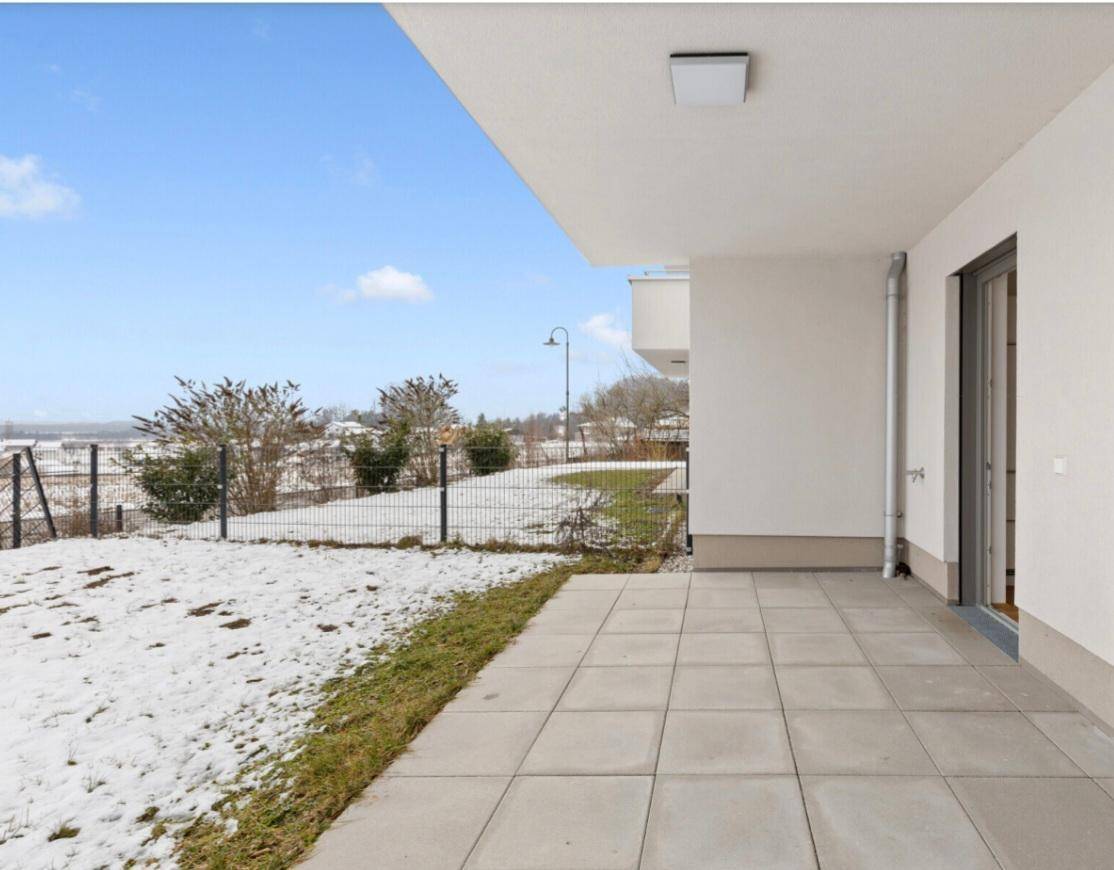 Geflieste Terrasse mit Blick auf den verschneiten Garten und die weite Landschaft.