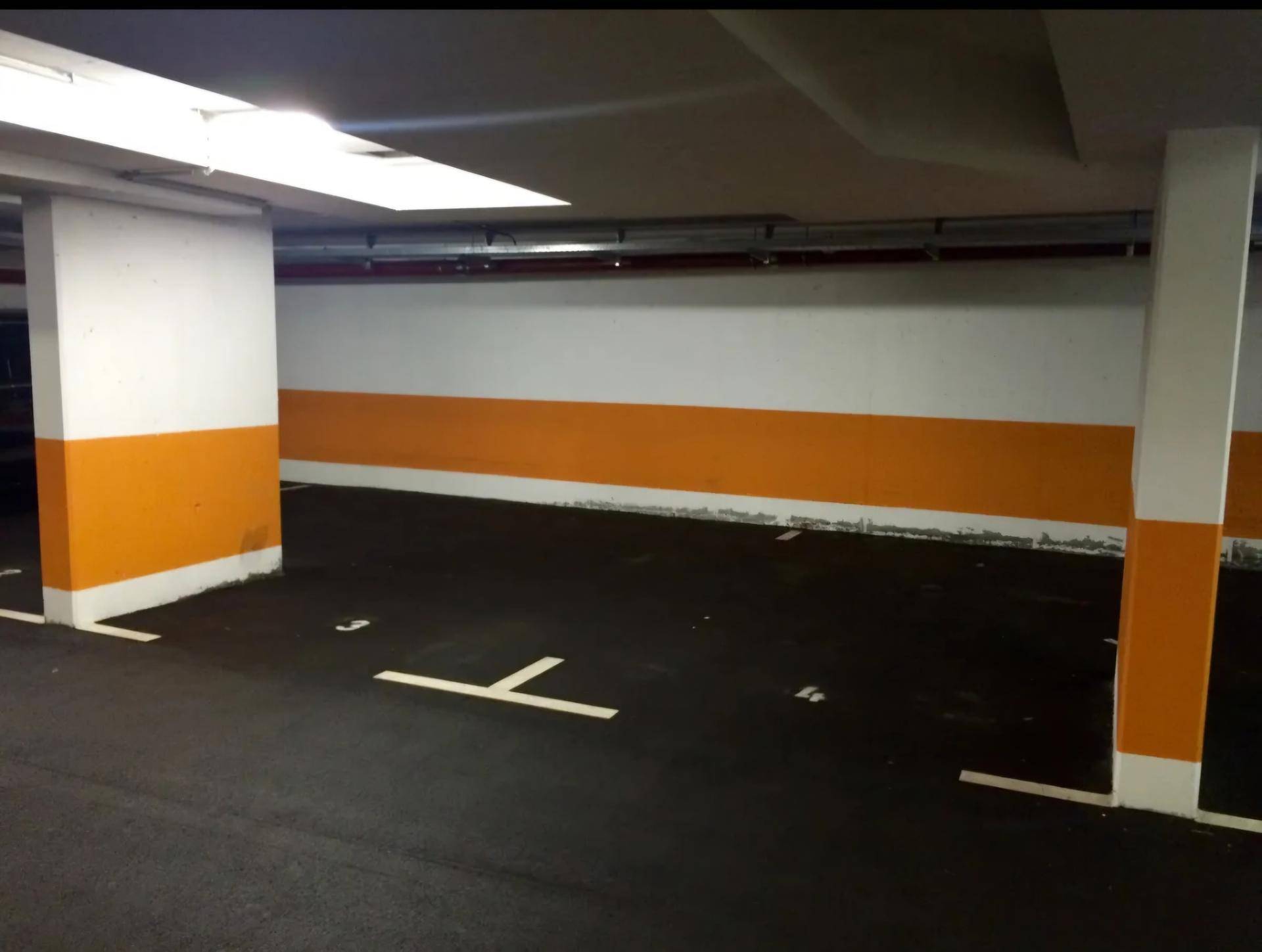 Geräumige Tiefgarage mit markierten Parkplätzen und guter Beleuchtung.