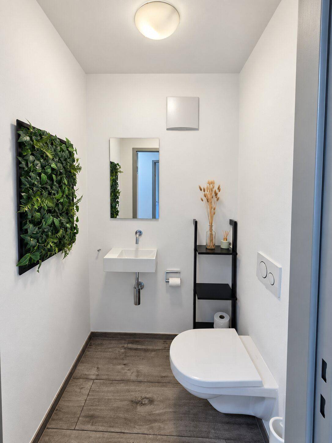 Modernes Gäste-WC mit wandhängender Toilette, kleinem Waschbecken und dekorativer Pflanzenwand.
