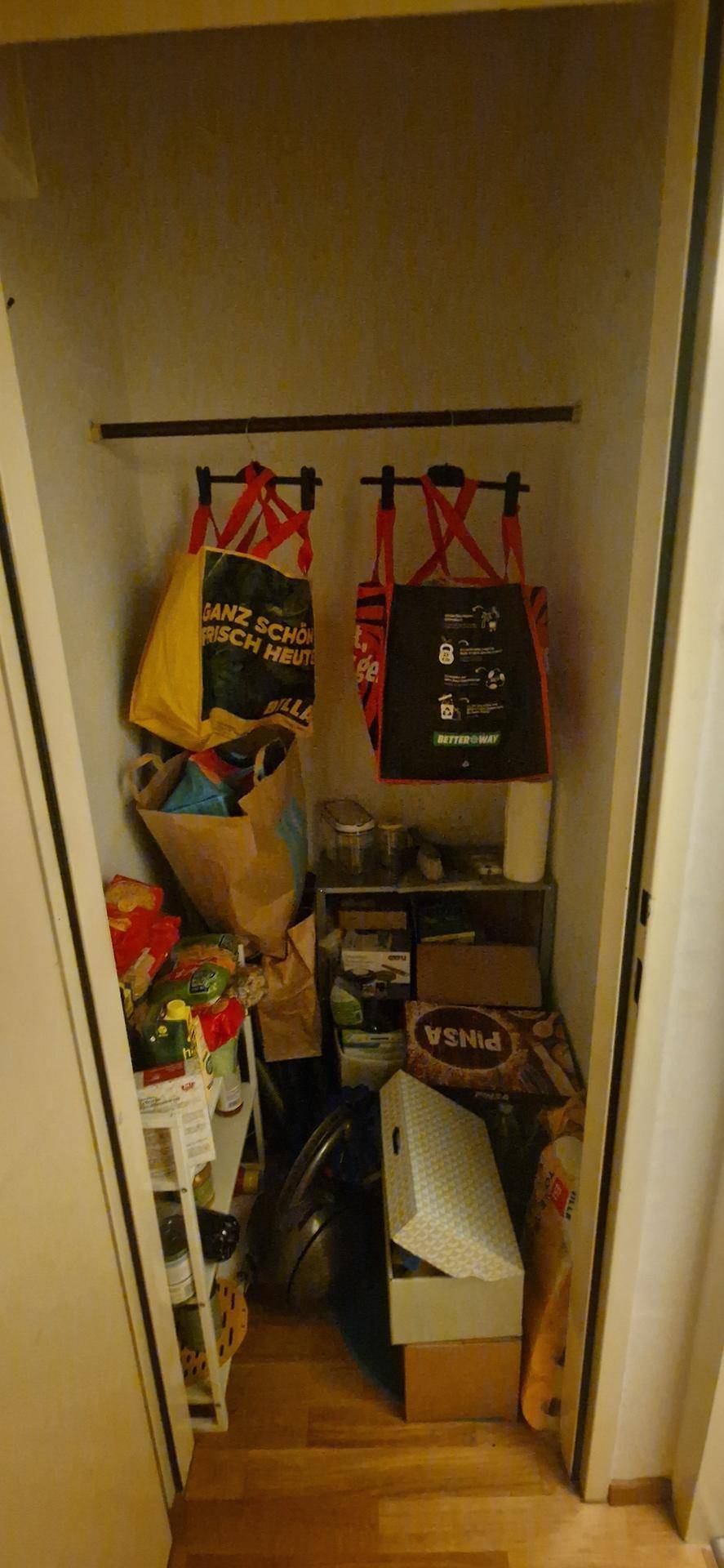 Kleiner Abstellraum mit Regalen und verschiedenen Haushaltsgegenständen, gut organisiert.