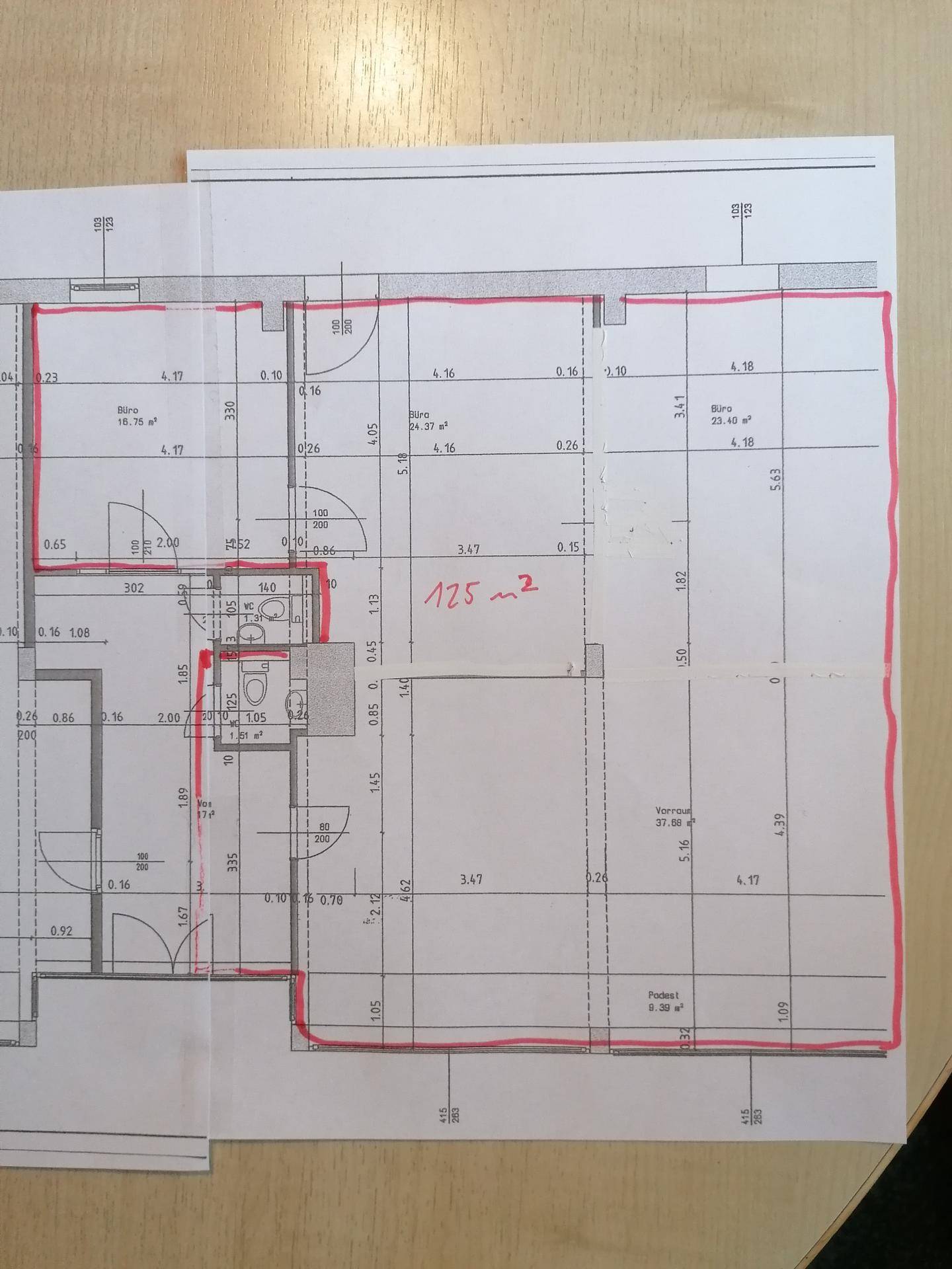 Grundrissplan mit verschiedenen Räumen, inklusive Büros und einem Badezimmer, mit roten Markierungen.