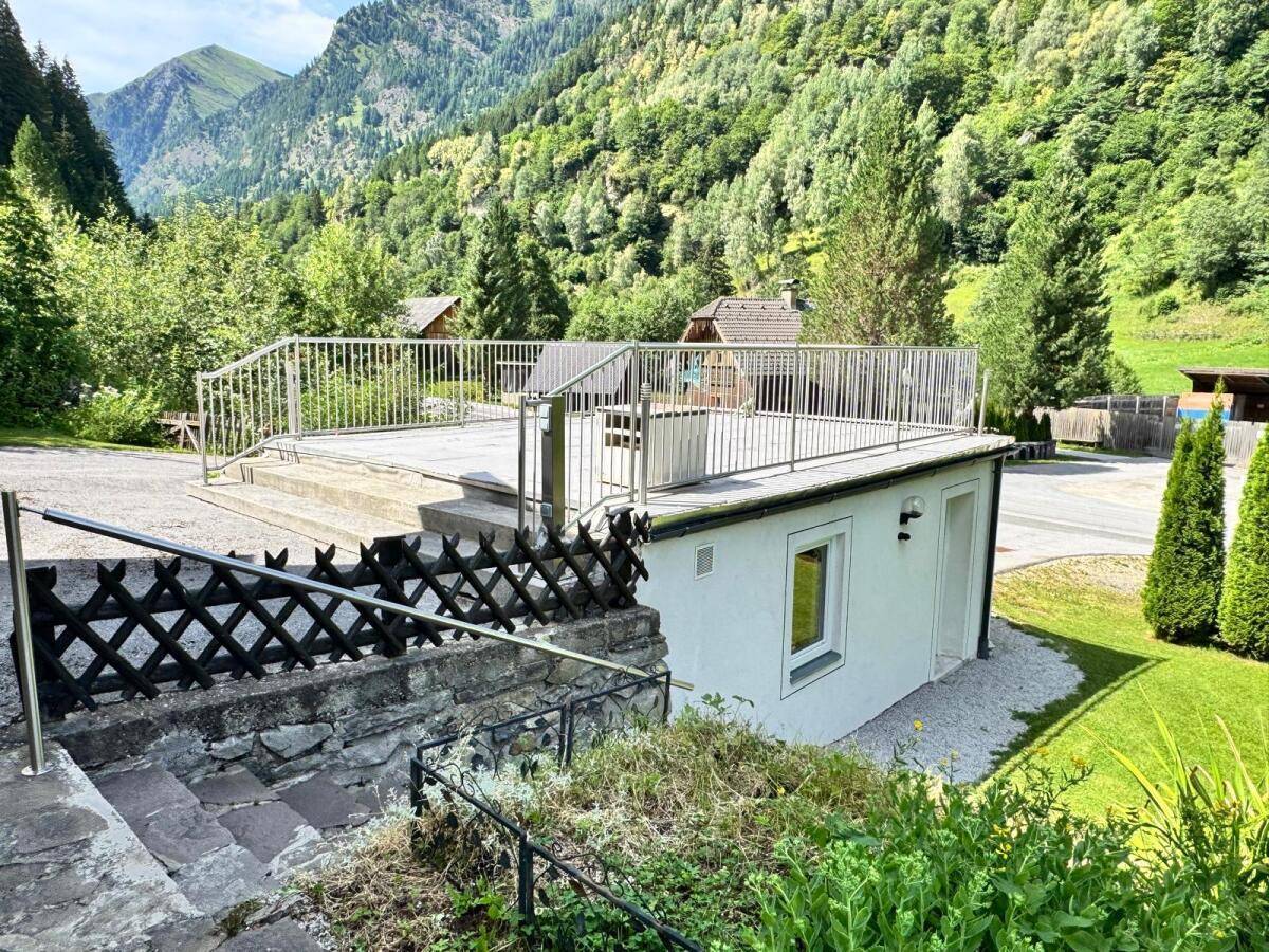 Geräumige Dachterrasse über der Garage mit Metallgeländer und weitem Blick auf die umliegenden Berge.