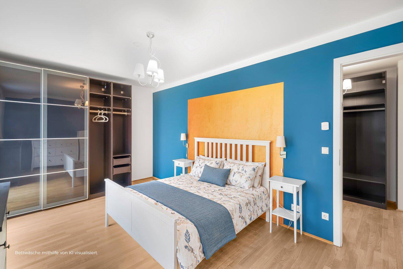 Helles Schlafzimmer mit blauer Akzentwand, Holzboden und großem Kleiderschrank.