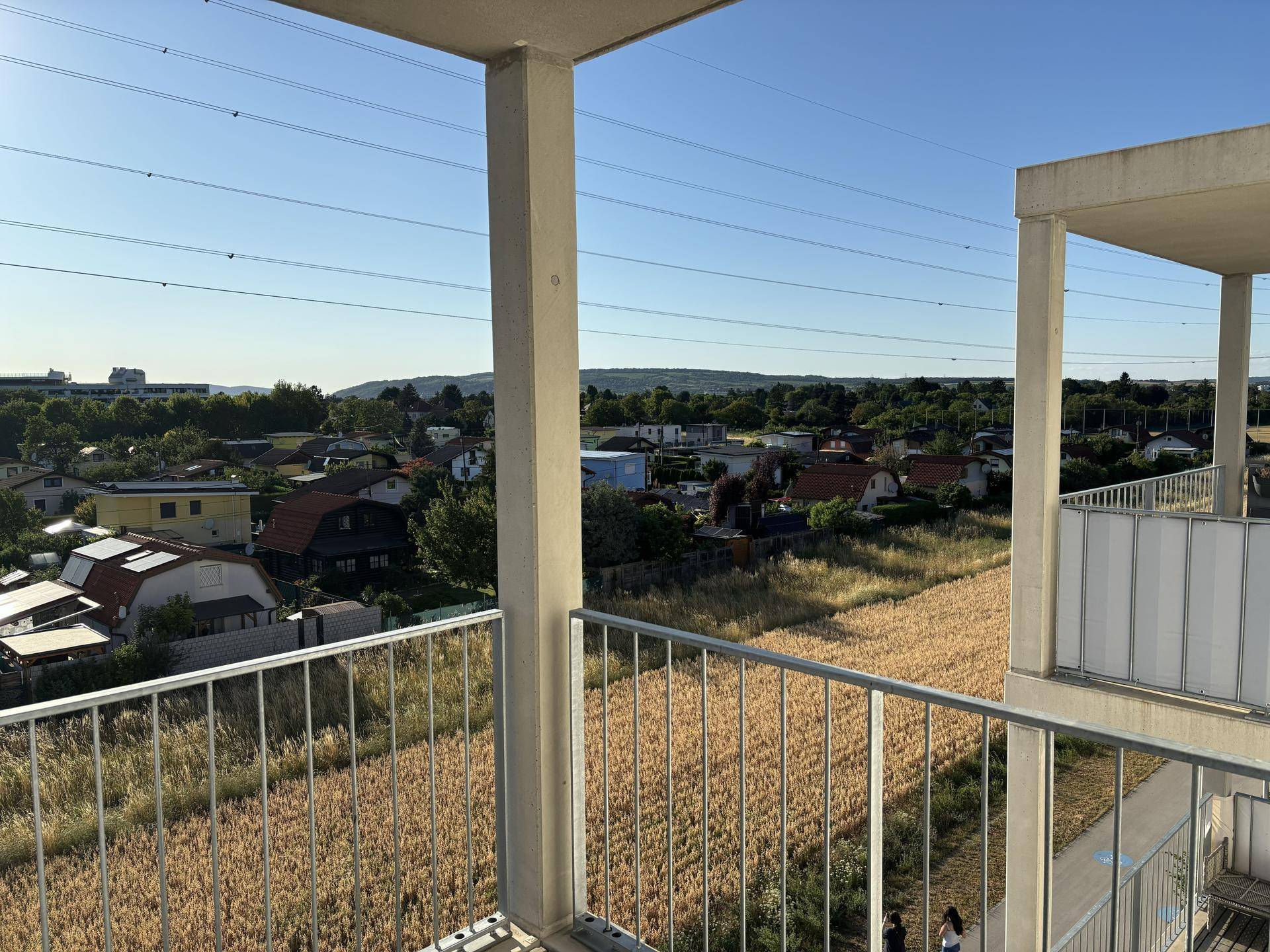 Geräumiger Balkon mit weitem Ausblick über die Dächer der Häuser und die Landschaft.