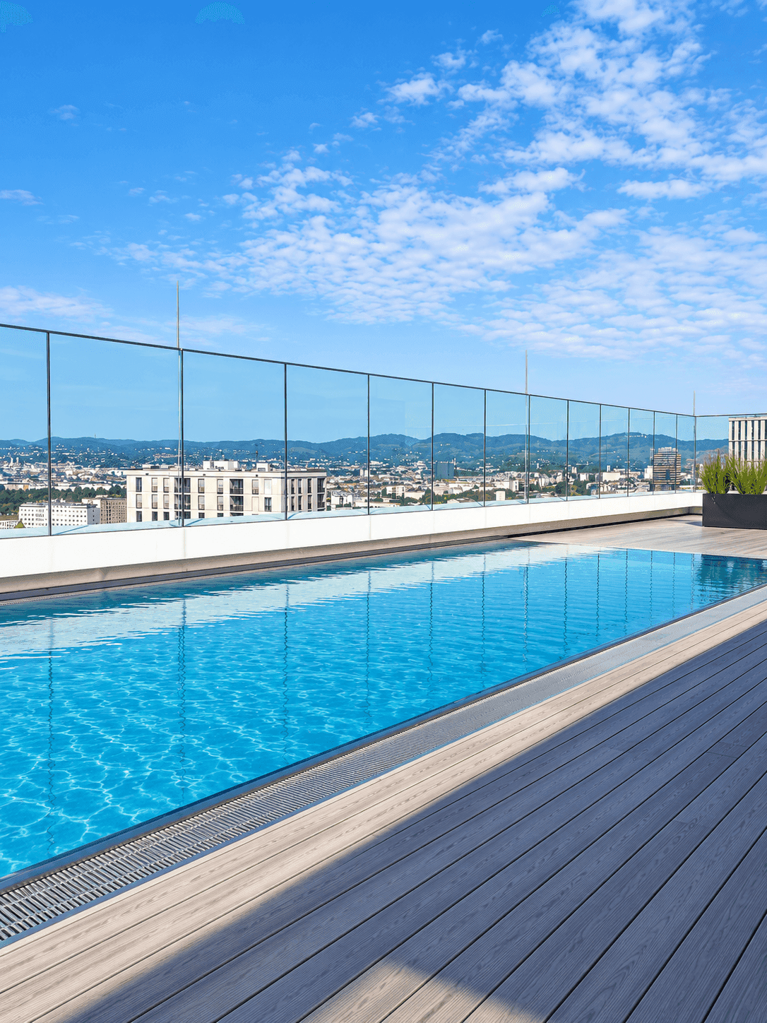 Dachterrassen-Pool mit Panoramablick auf die Stadt und die Berge in der Ferne.