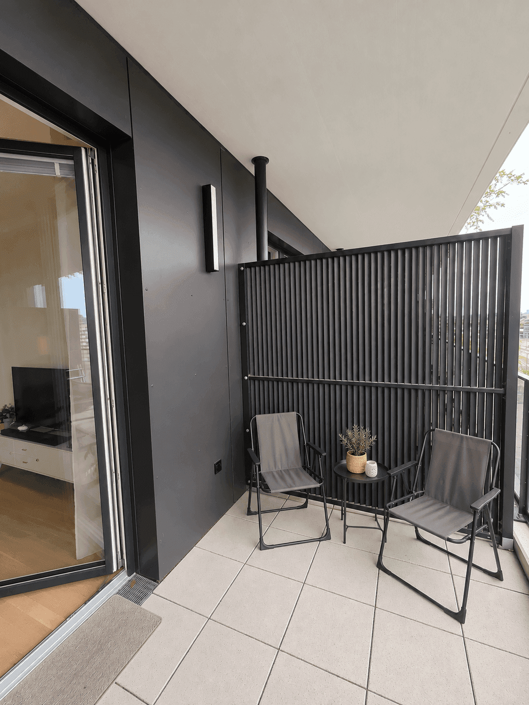 Balkon mit zwei Stühlen und einem kleinen Tisch, ideal für eine private Sitzecke.