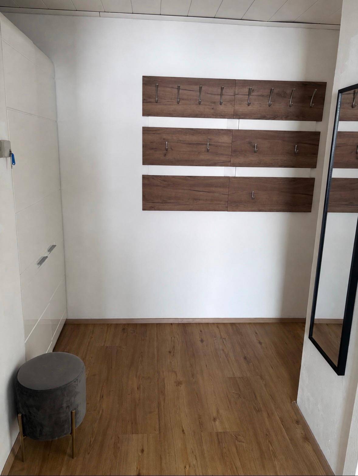 Geräumiger Flur mit Holzboden, Garderobe und großem Spiegel für den Eingangsbereich.