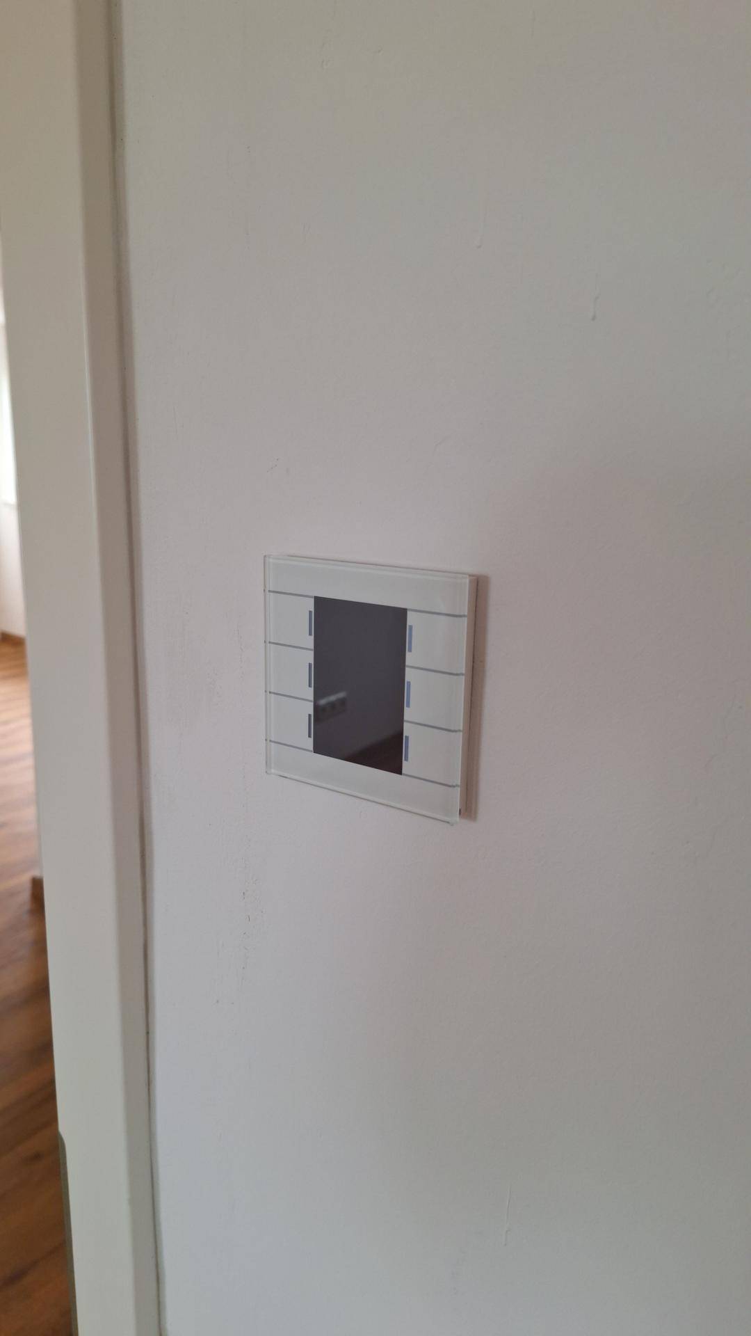 Modernes Lichtschalterpanel an einer weißen Wand, das die Steuerung der Beleuchtung ermöglicht und elegant wirkt.
