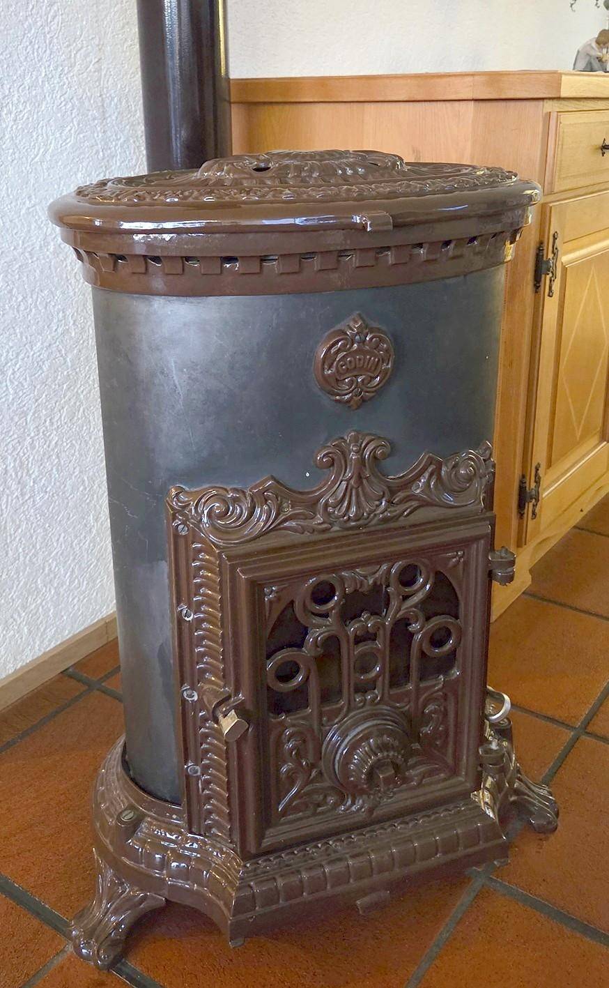 Detailaufnahme eines traditionellen, verzierten Holzofens mit gusseisernen Elementen.