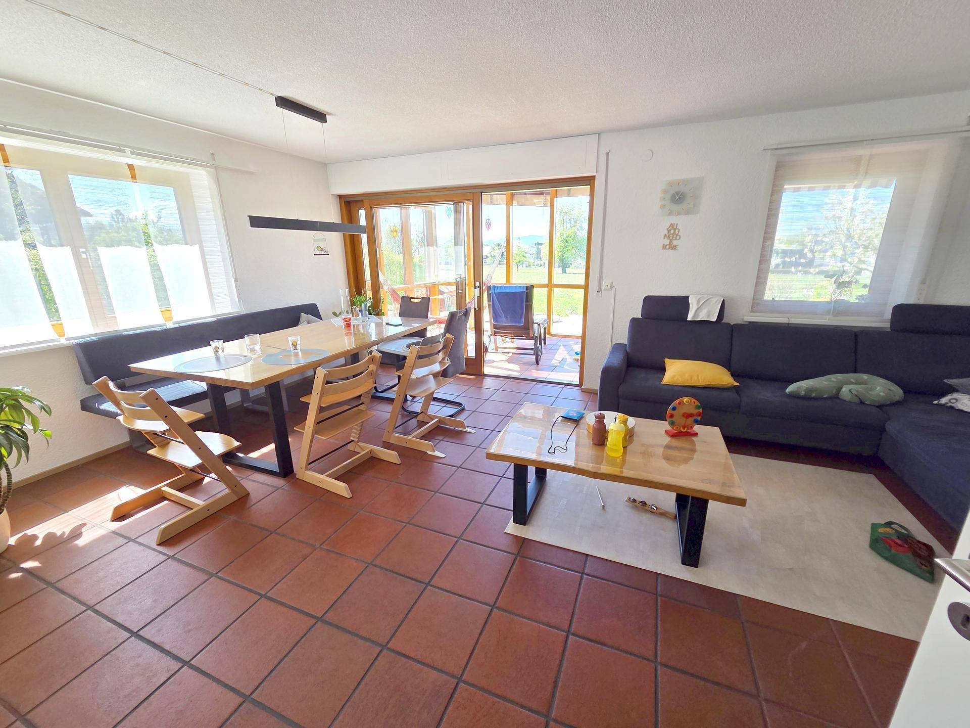 Geräumiger Wohn-Essbereich mit Terrakottafliesen und direktem Zugang zum Wintergarten.