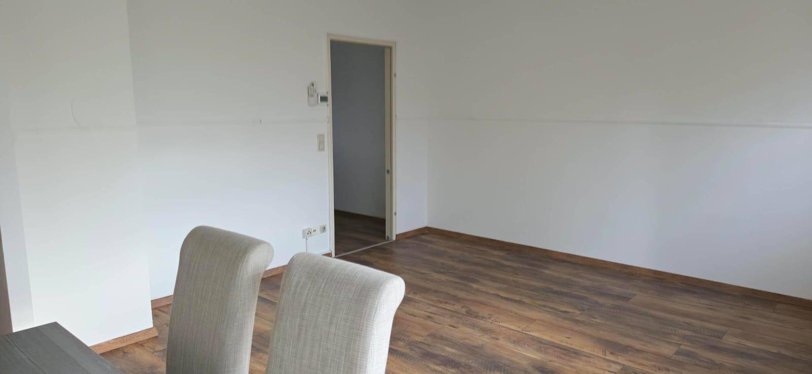 Geräumiger Essbereich mit Laminatboden und weiß gestrichenen Wänden, bietet viel Platz.