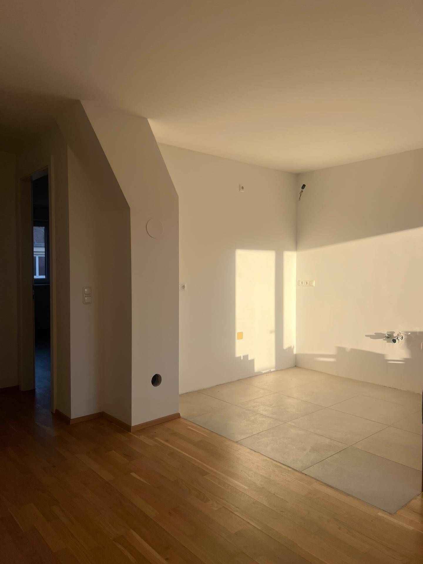Offener Wohnbereich mit Holzboden und Fliesen, ideal für eine moderne Wohnküche.