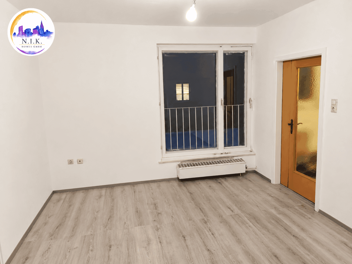 Geräumiges Zimmer mit Laminatboden, großem Fenster und Heizkörper, ideal für Wohnzwecke.