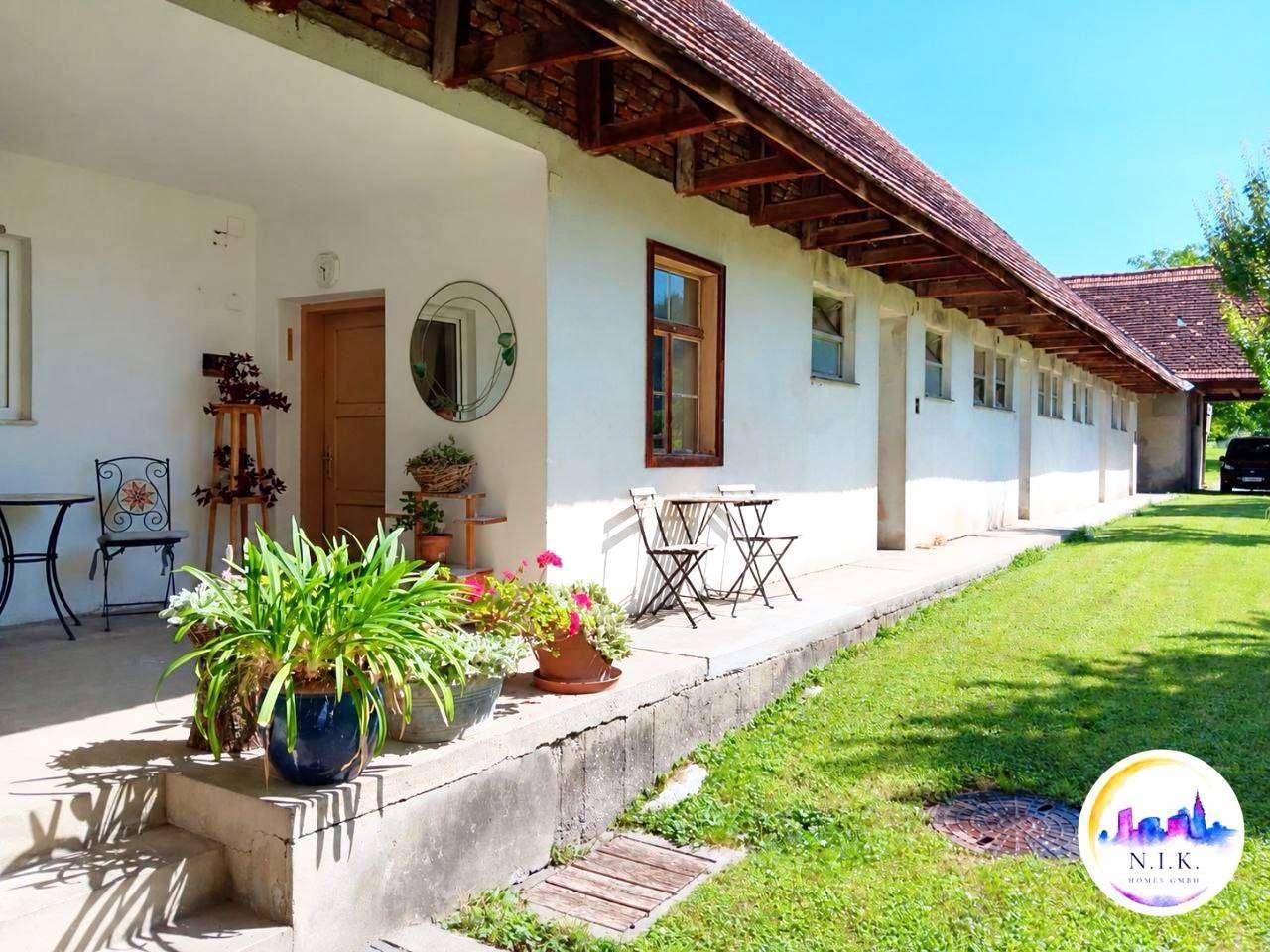 Überdachte Terrasse mit Sitzgelegenheiten und Topfpflanzen, ideal für entspannte Stunden im Freien.