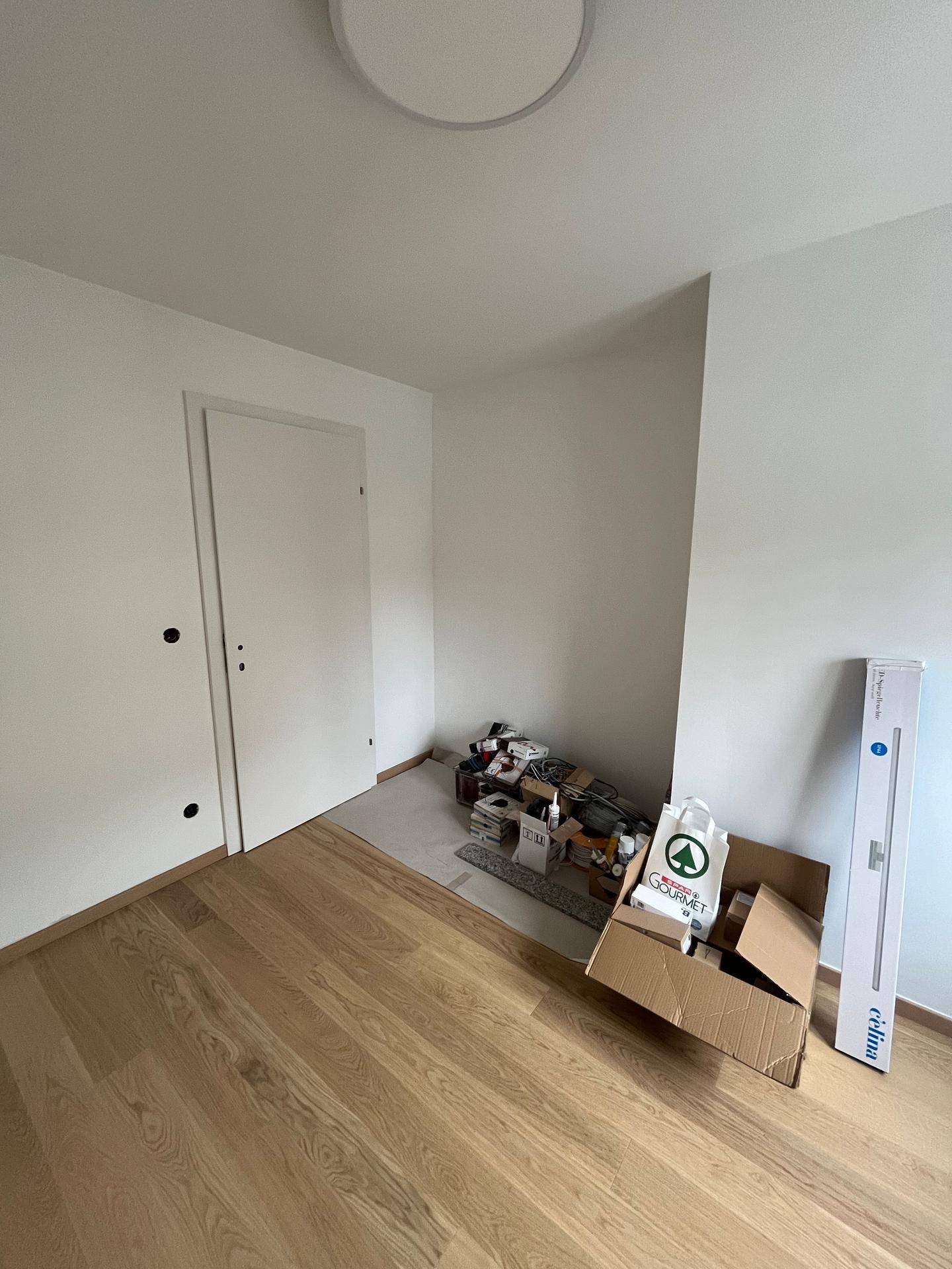 Helles Zimmer mit neuem Parkettboden und weiß gestrichenen Wänden, bereit zum Einzug.