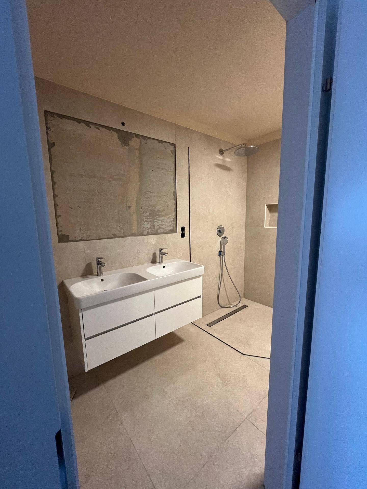 Modernes Badezimmer mit Doppelwaschbecken und ebenerdiger Dusche, ausgestattet mit Regendusche.