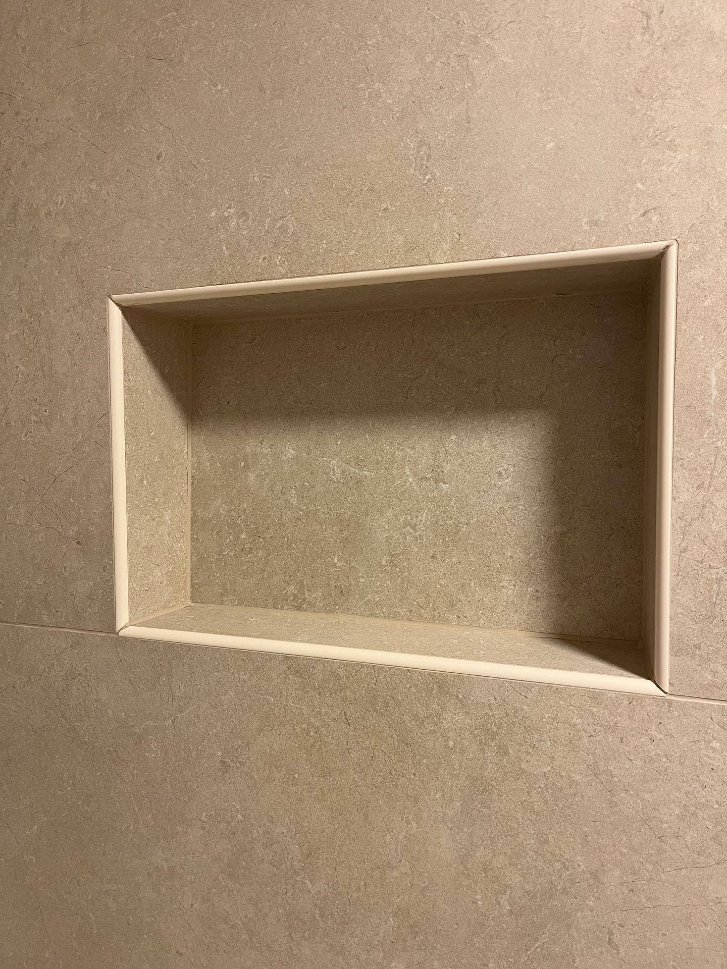 Integrierte Nische in der Duschwand, praktisch für Badutensilien und modernes Designelement.