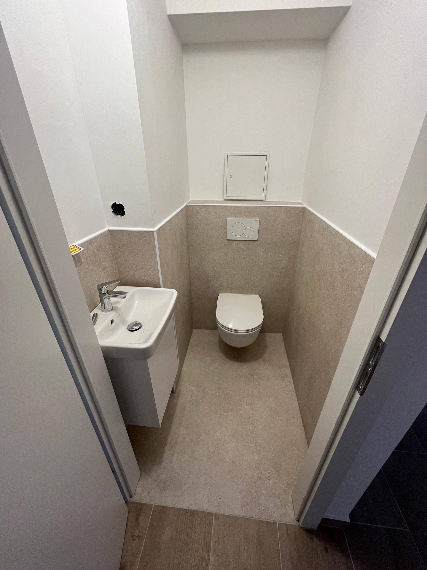 Modernes Gäste-WC mit wandhängender Toilette und kleinem Waschbecken, praktisch und platzsparend.