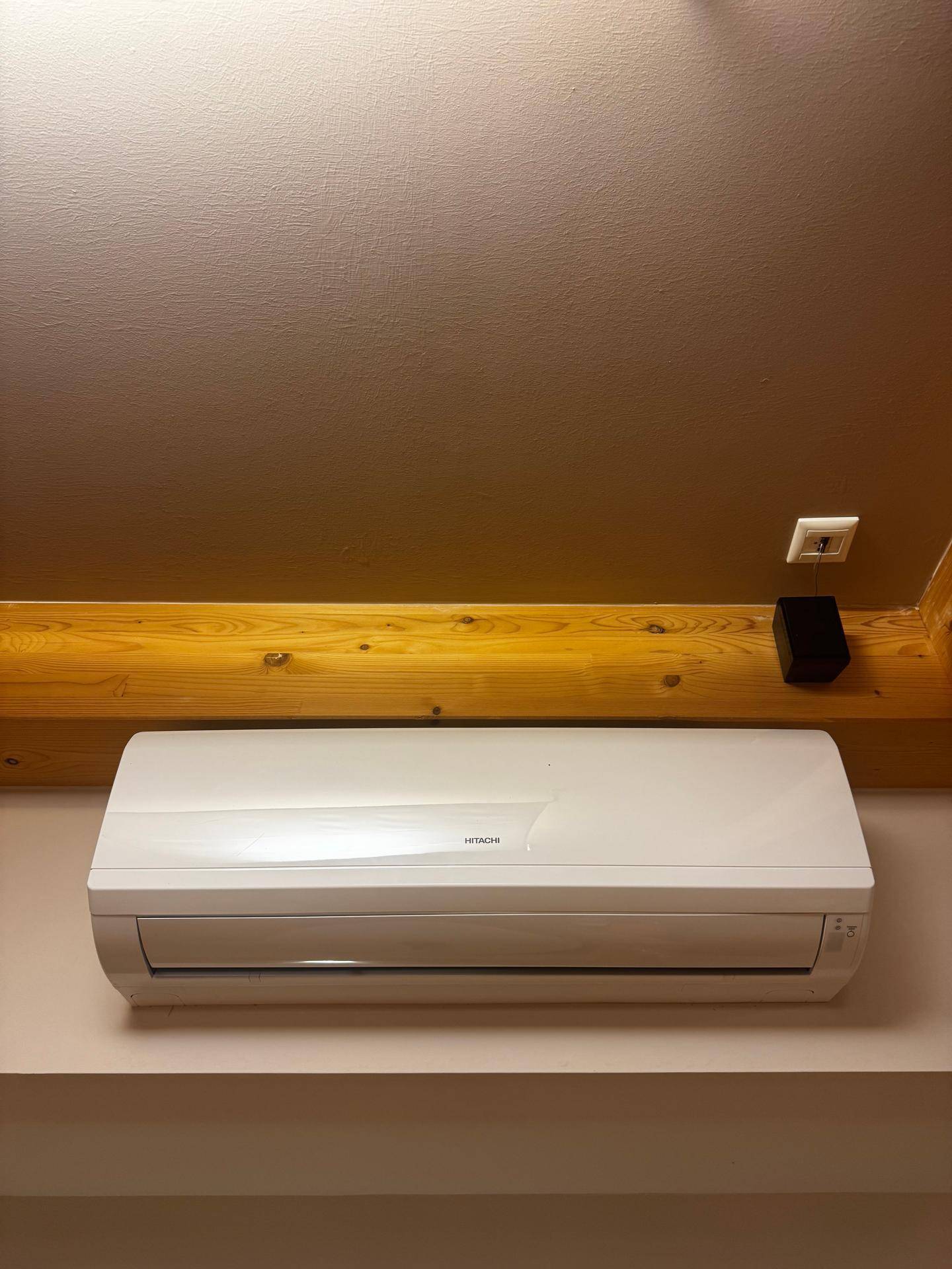 Eine moderne Klimaanlage der Marke Hitachi ist an der Wand montiert.
