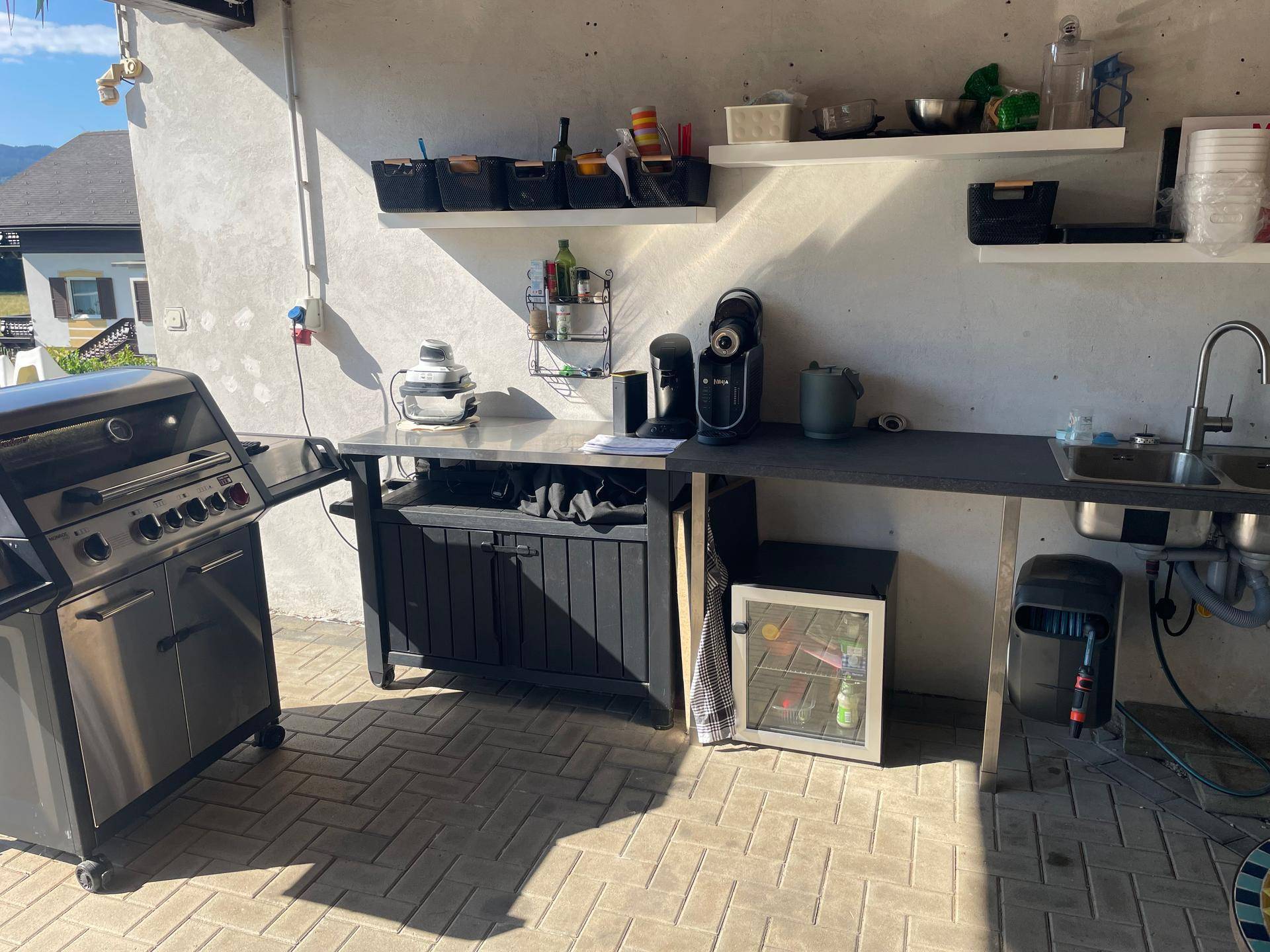 Gut ausgestattete Außenküche mit Grill, Spüle und Kaffeemaschinen, mit Bergblick.