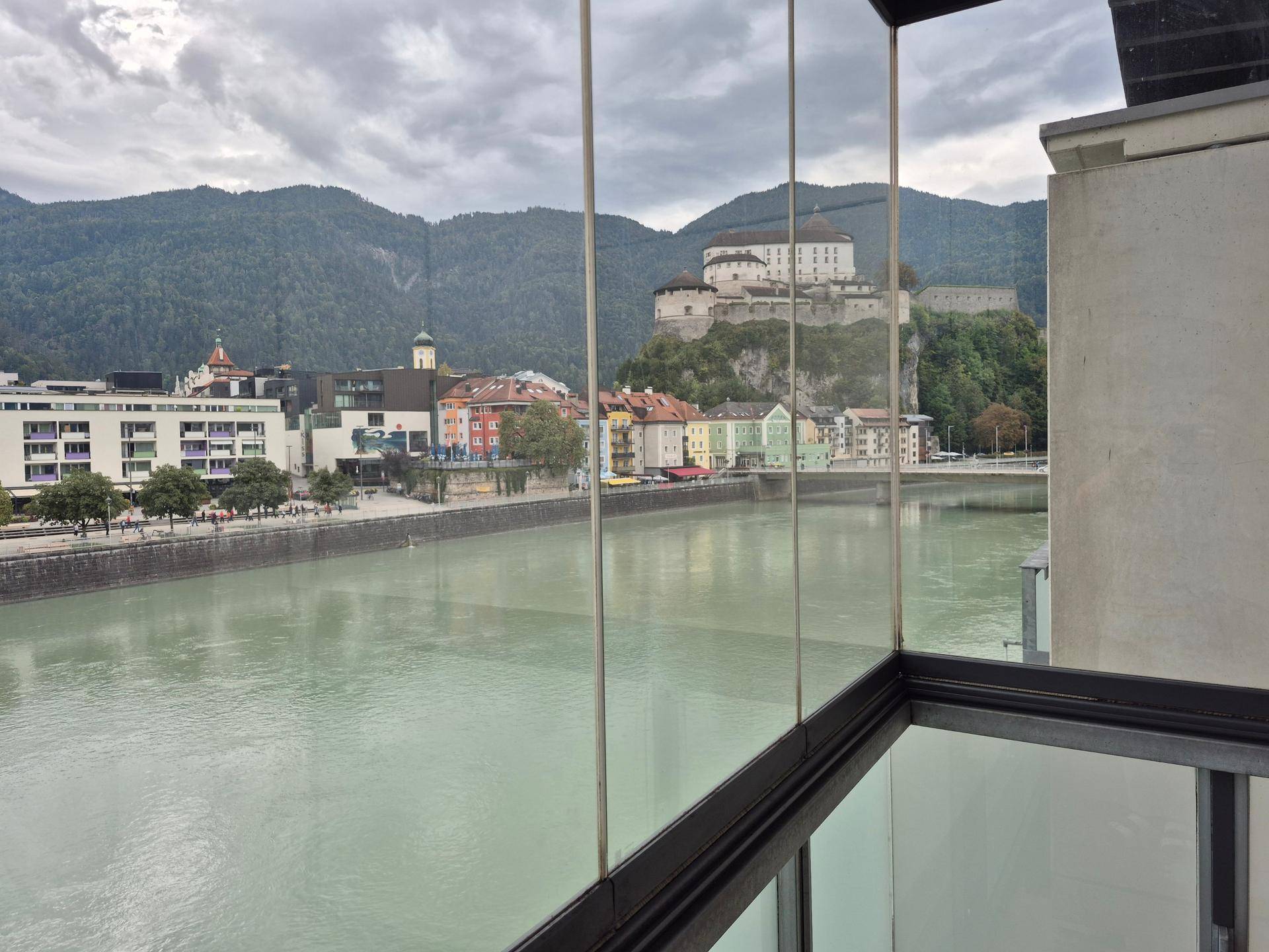 Panoramablick von der Loggia auf den Fluss, die Stadt, eine Burg und die umliegenden Berge.