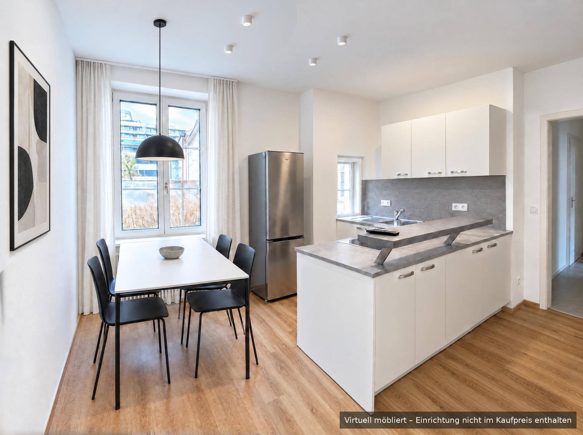 Moderne Küche mit Essbereich, weißen Schränken, grauen Arbeitsplatten und Holzfußboden.