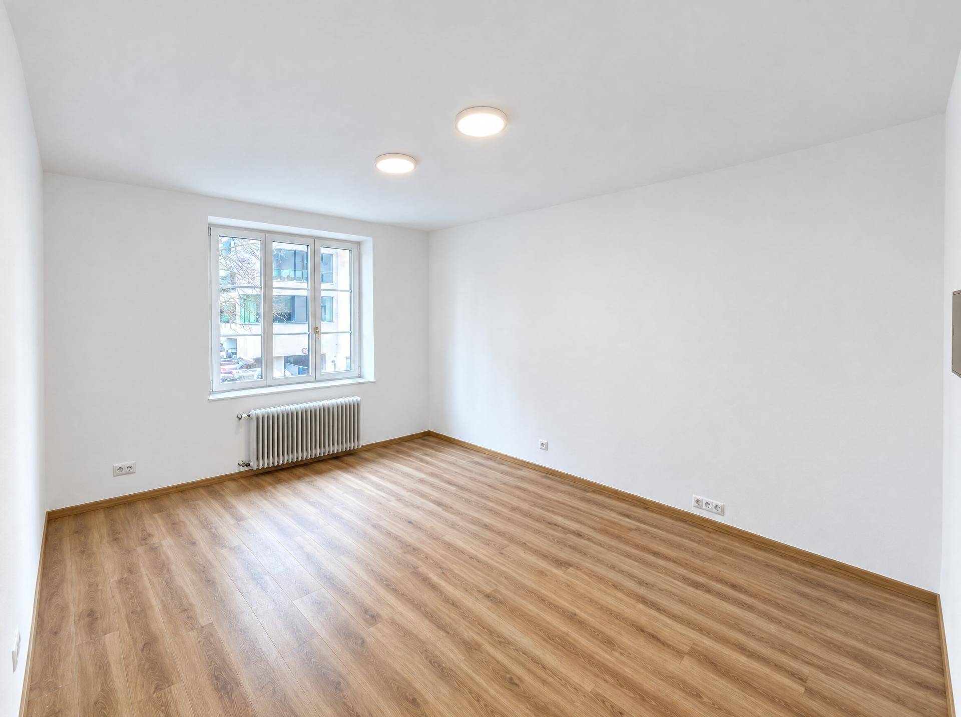 Geräumiger, heller Raum mit Laminatboden und einem Fenster, vielseitig nutzbar als Schlafzimmer.