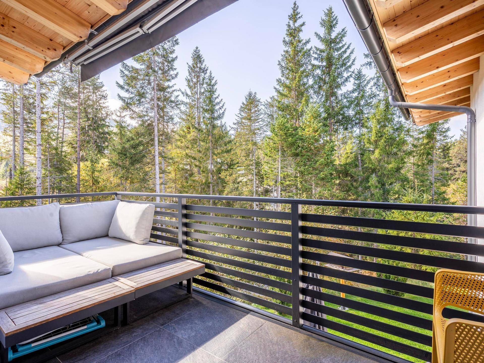 Balkon mit Sitzgelegenheiten und weitem Blick auf die umliegenden Wälder.