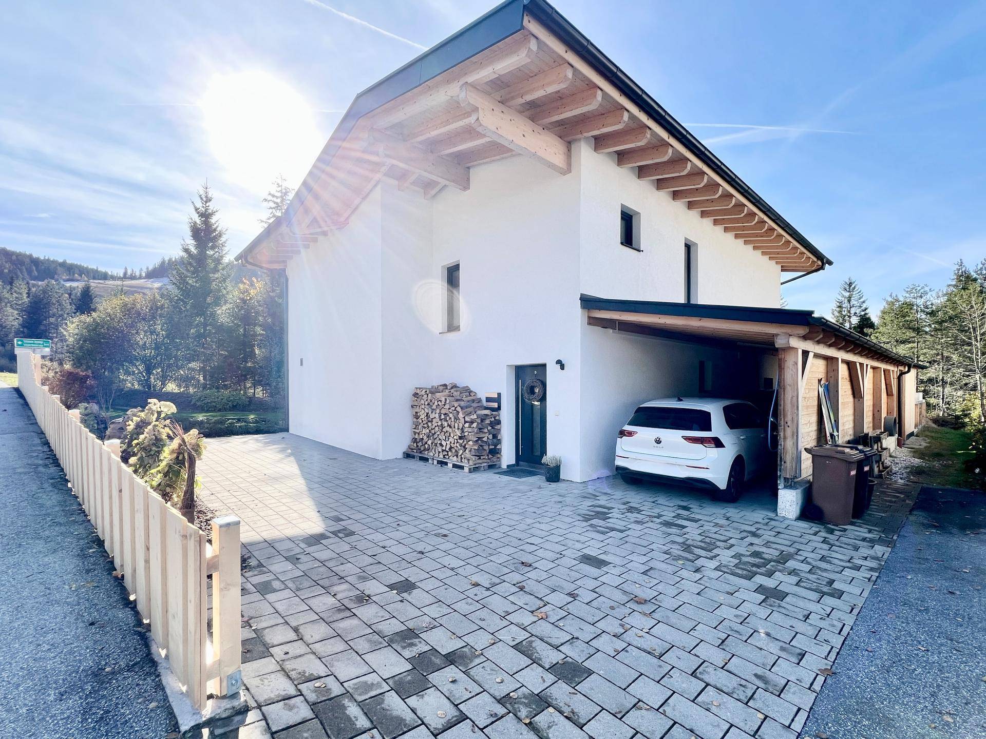 Vorderansicht des Hauses mit gepflasterter Einfahrt und Carport.