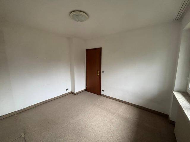 Leeres Schlafzimmer mit Teppichboden und einfacher Ausstattung.