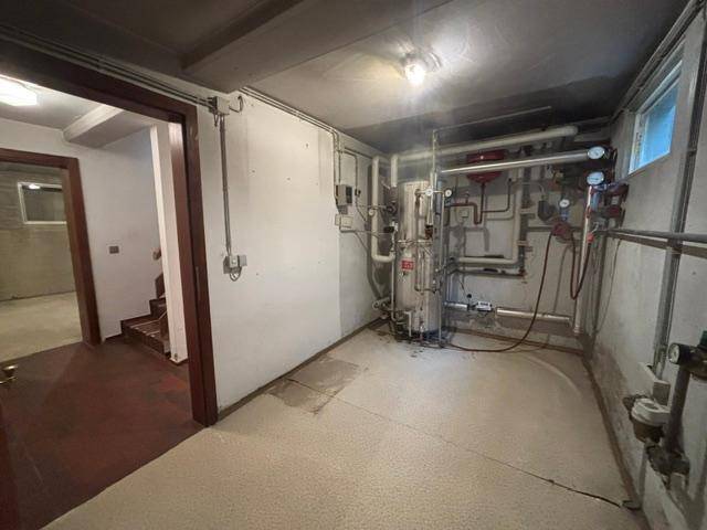 Heizungsraum im Keller mit sichtbaren Rohren und technischer Ausstattung.