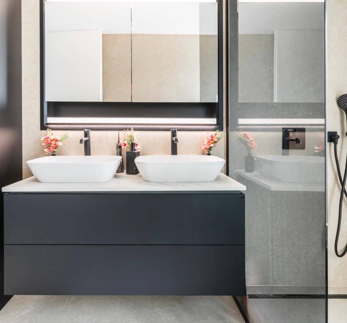 Modernes Badezimmer mit Doppelwaschbecken, Spiegelschrank und begehbarer Dusche mit schwarzer Armatur.
