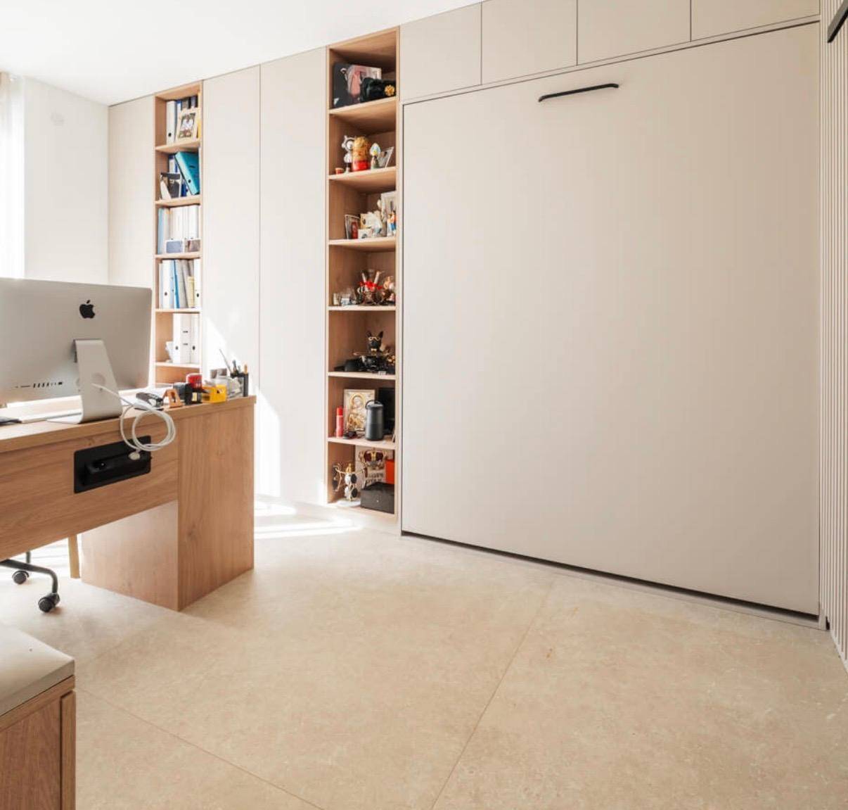Modernes Arbeitszimmer mit integrierten Regalen und einem platzsparenden Schrankbett für Gäste.
