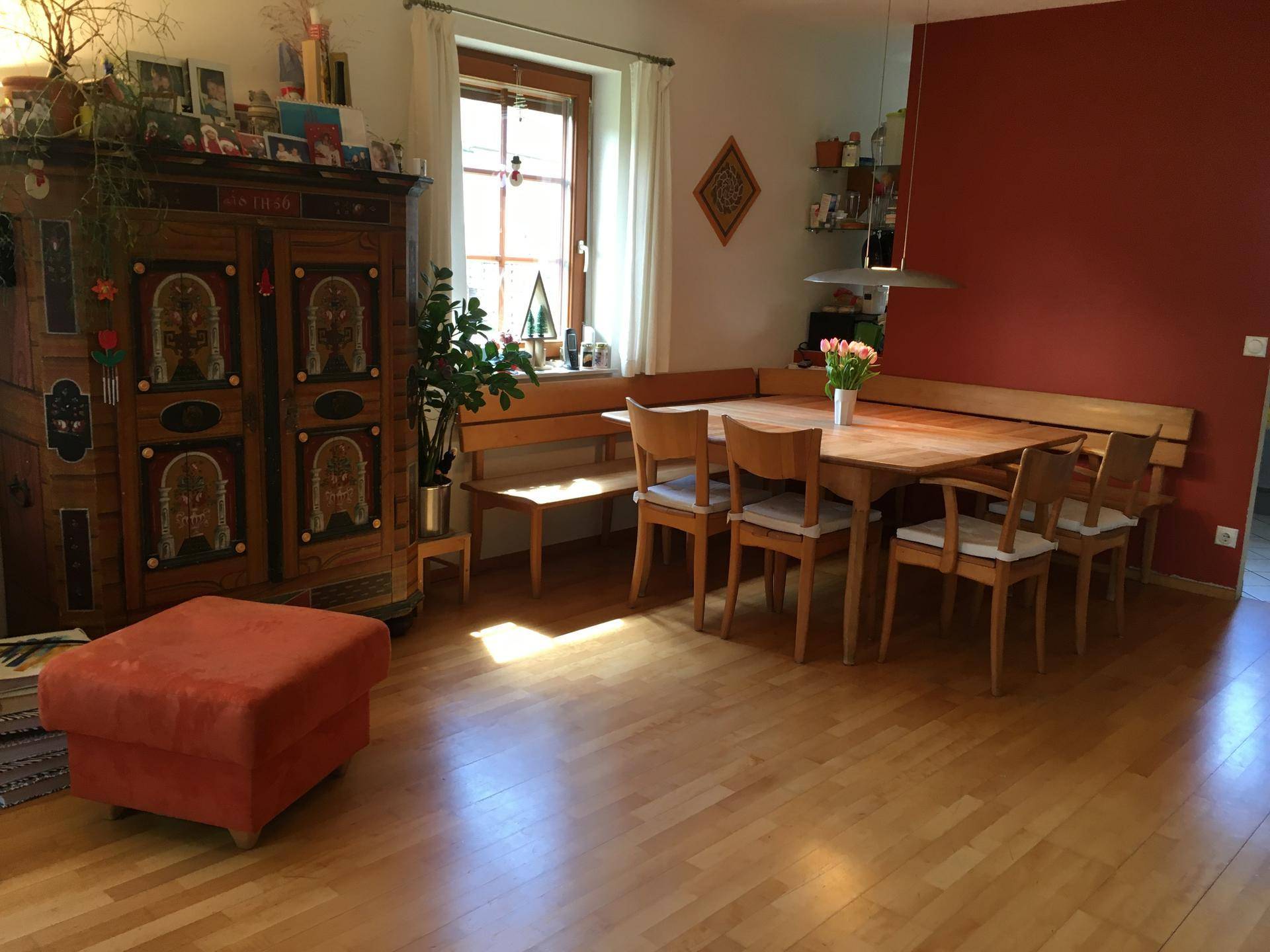 Gemütlicher Essbereich mit großem Holztisch, Eckbank und traditionellem Schrank auf Parkettboden.