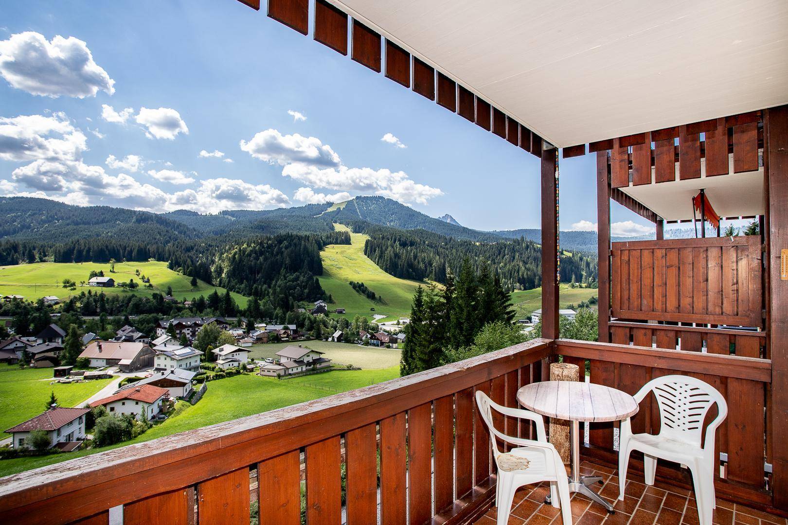 Einladender Balkon mit Sitzgelegenheiten und beeindruckendem Ausblick auf die Alpenlandschaft.