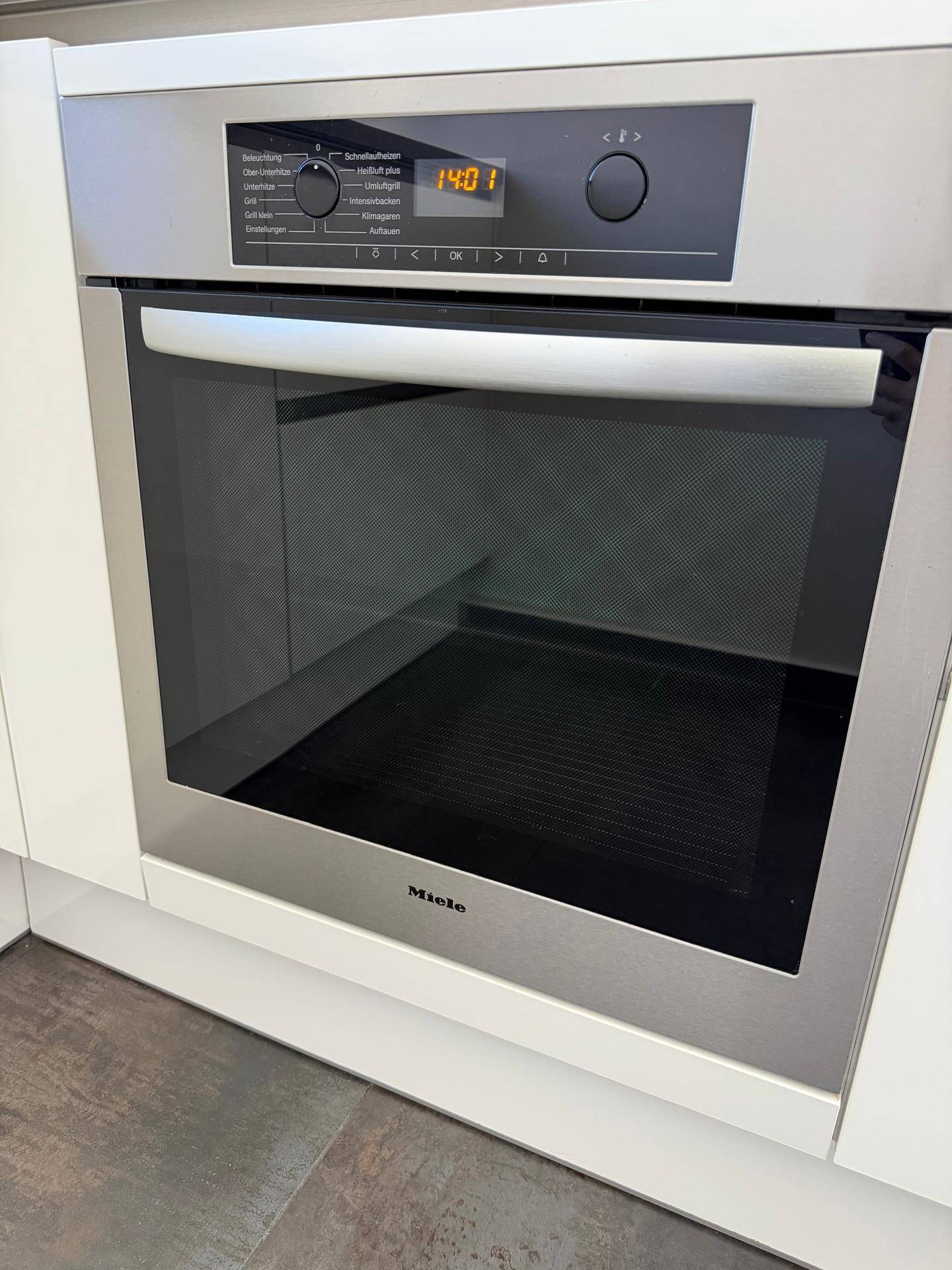 Eingebauter Miele-Backofen mit digitaler Anzeige und Edelstahloberfläche in der Küche.