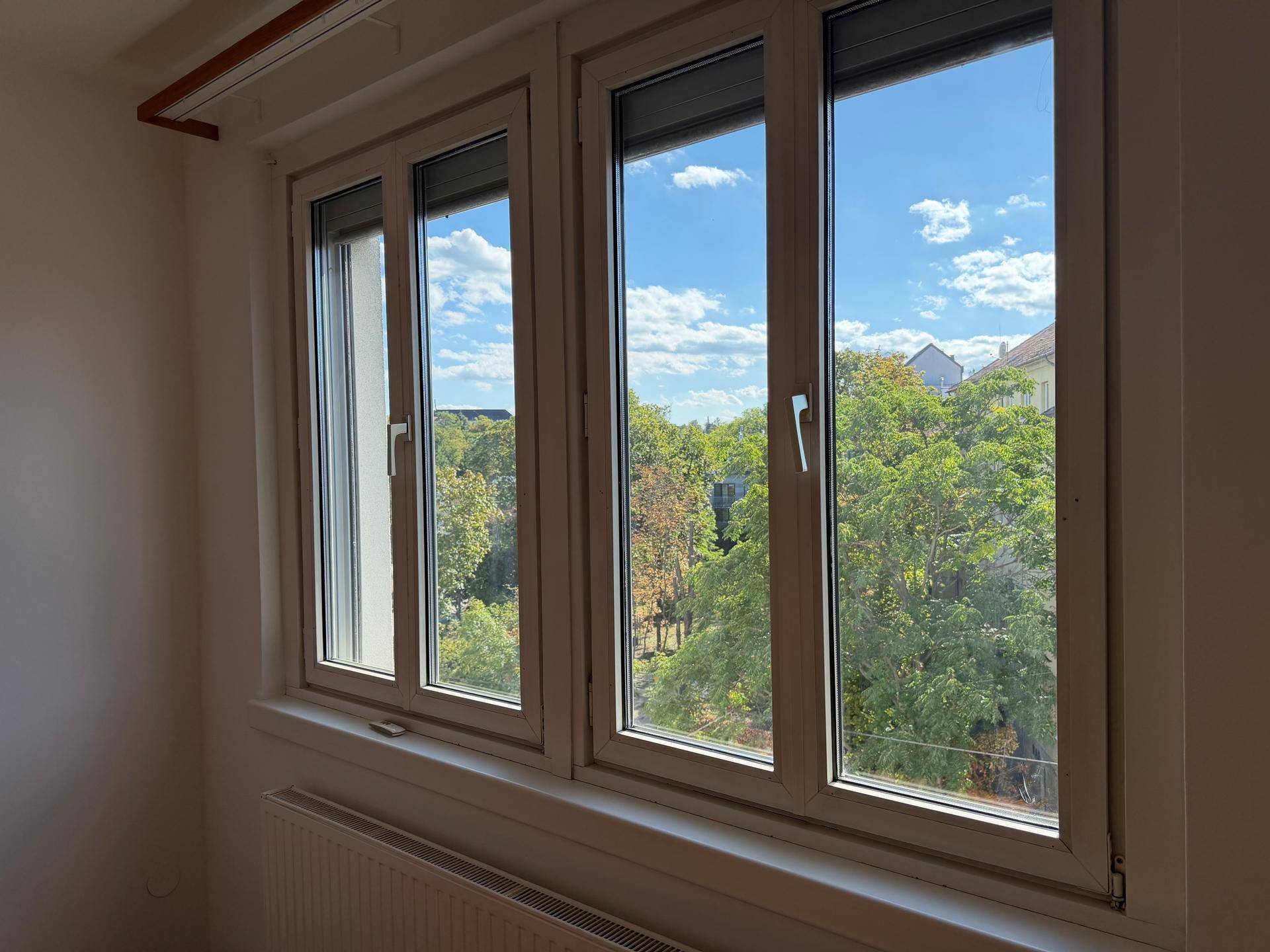 Fenster mit Blick ins Grüne und auf den blauen Himmel, das viel Tageslicht bietet.
