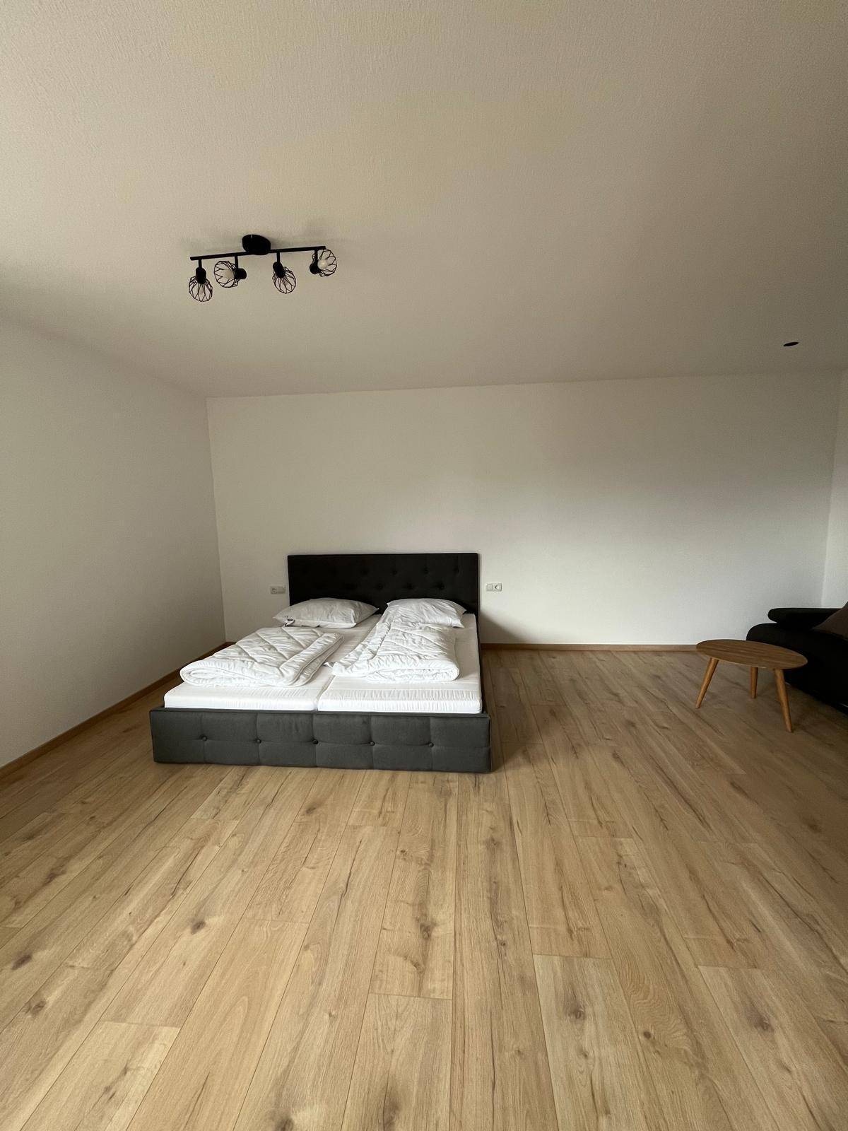Geräumiges Schlafzimmer mit Doppelbett und kleinem Beistelltisch, ideal für erholsame Nächte.