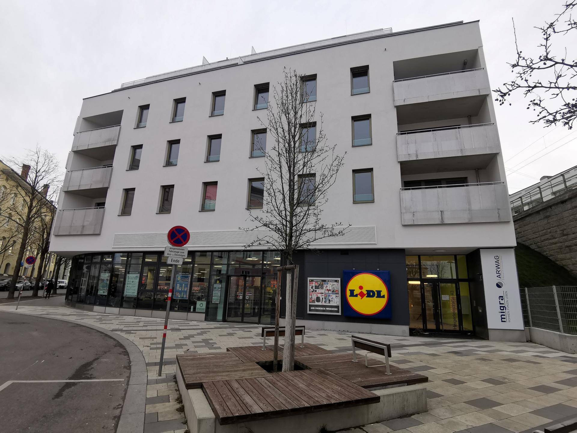 Modernes Gebäude mit einem Lidl-Supermarkt im Erdgeschoss und Wohnungen darüber.