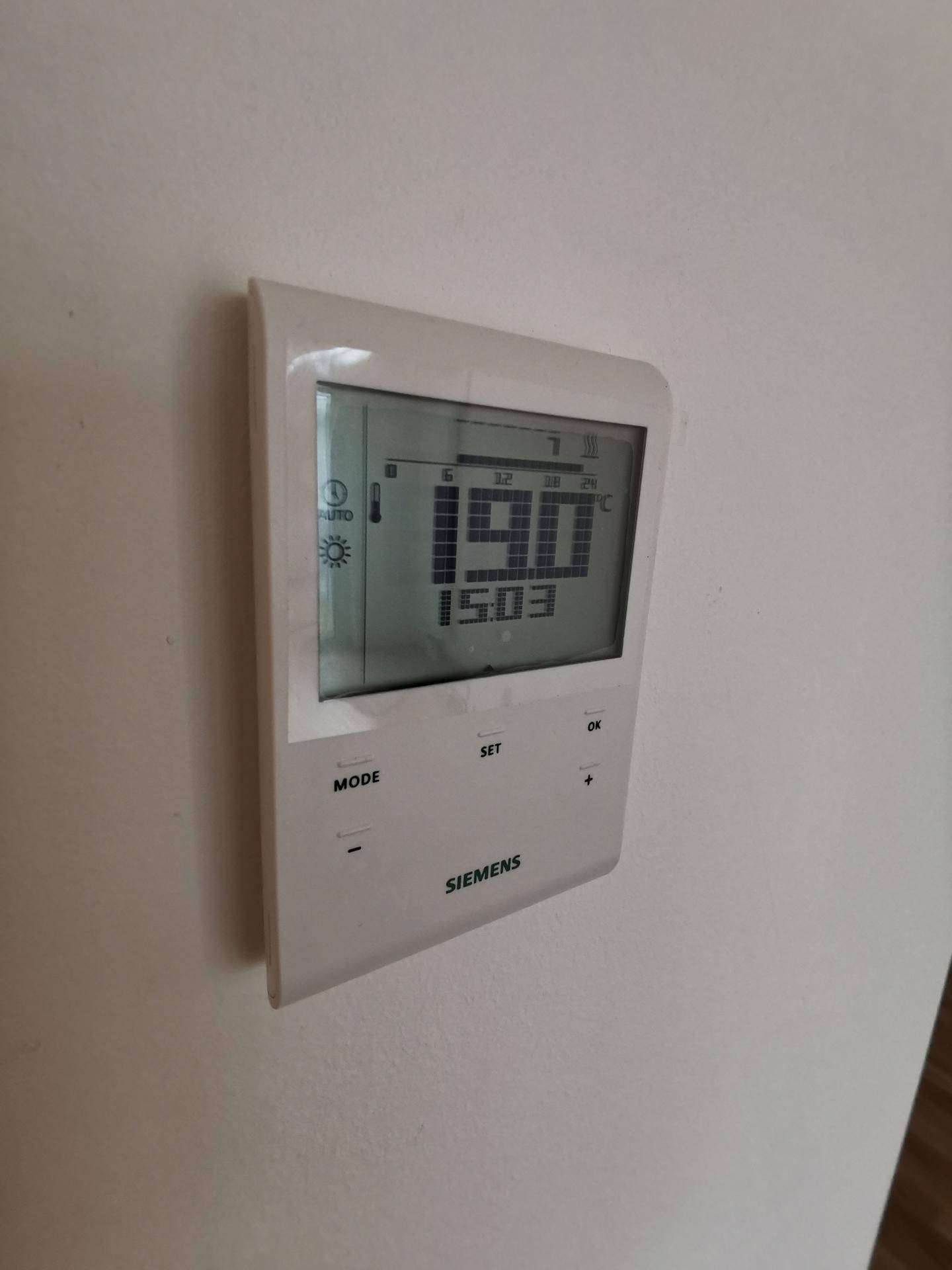 Digitaler Siemens-Thermostat an der Wand zur präzisen Steuerung der Raumtemperatur.