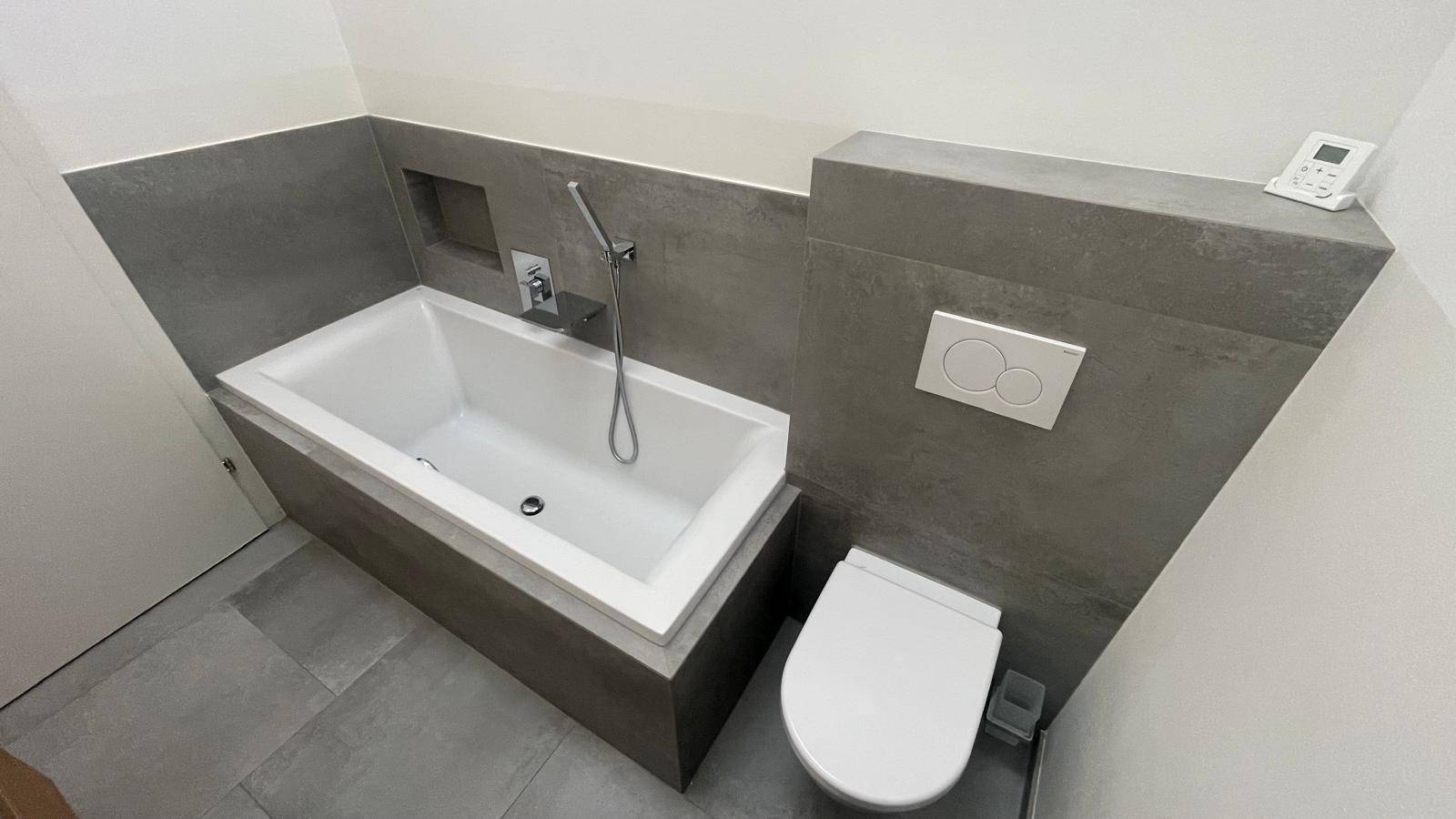 Helles Badezimmer mit integrierter Badewanne und wandhängendem WC.