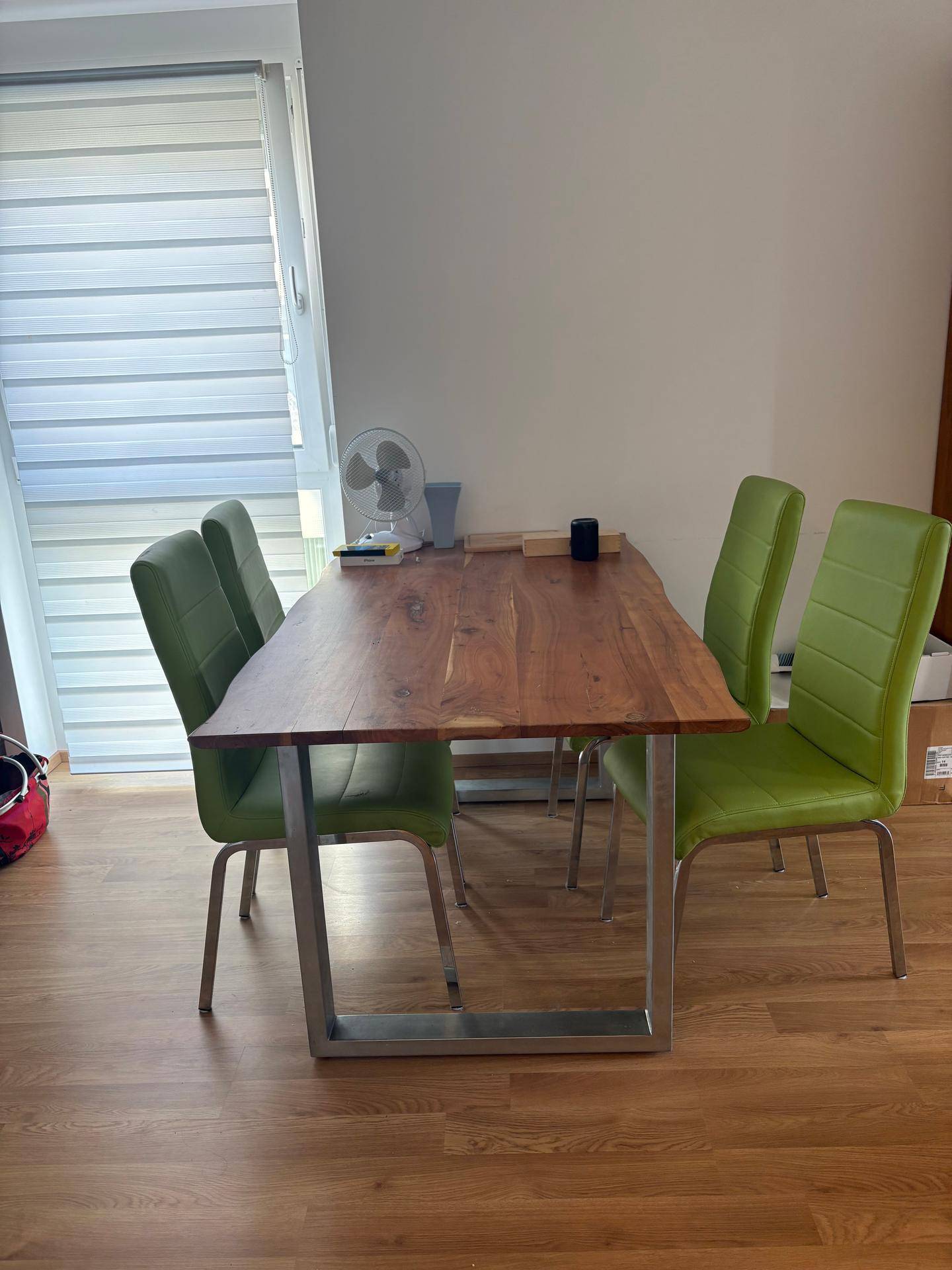 Essbereich mit rustikalem Holztisch und modernen grünen Stühlen, ideal für gemeinsame Mahlzeiten.