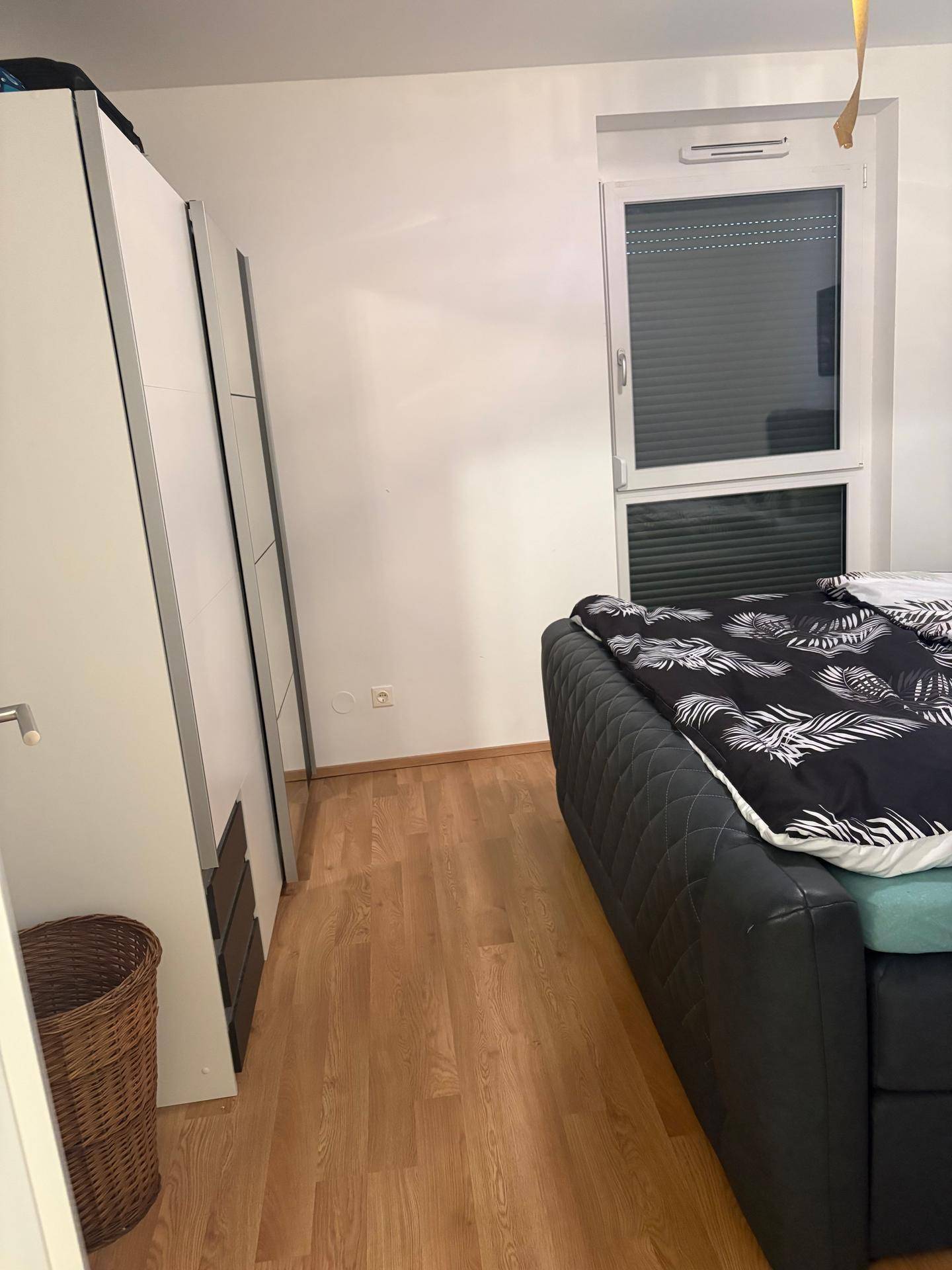 Schlafzimmer mit großem Kleiderschrank und Fenster mit Rollläden, bietet ausreichend Stauraum.