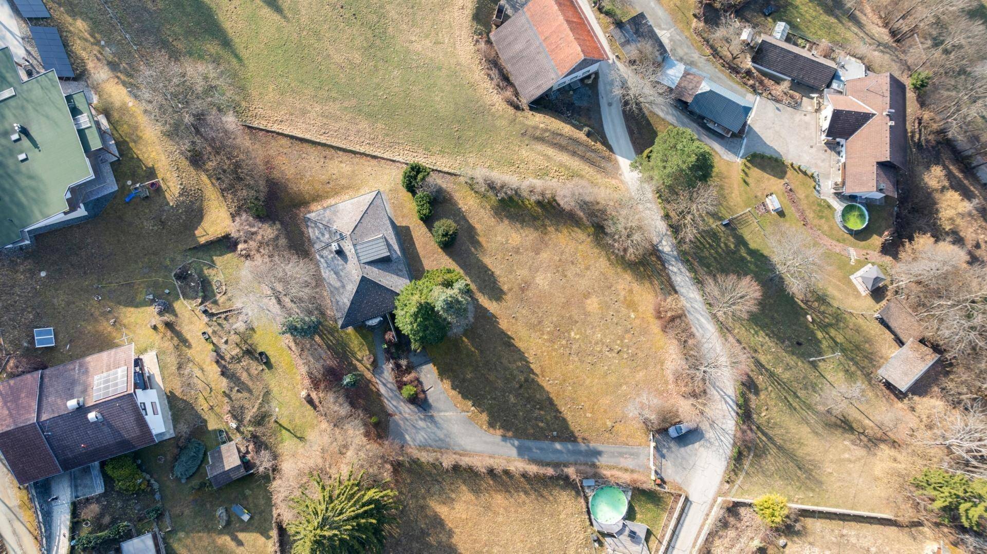 Luftaufnahme des Grundstücks mit Haus, Auffahrt und umliegender Natur.