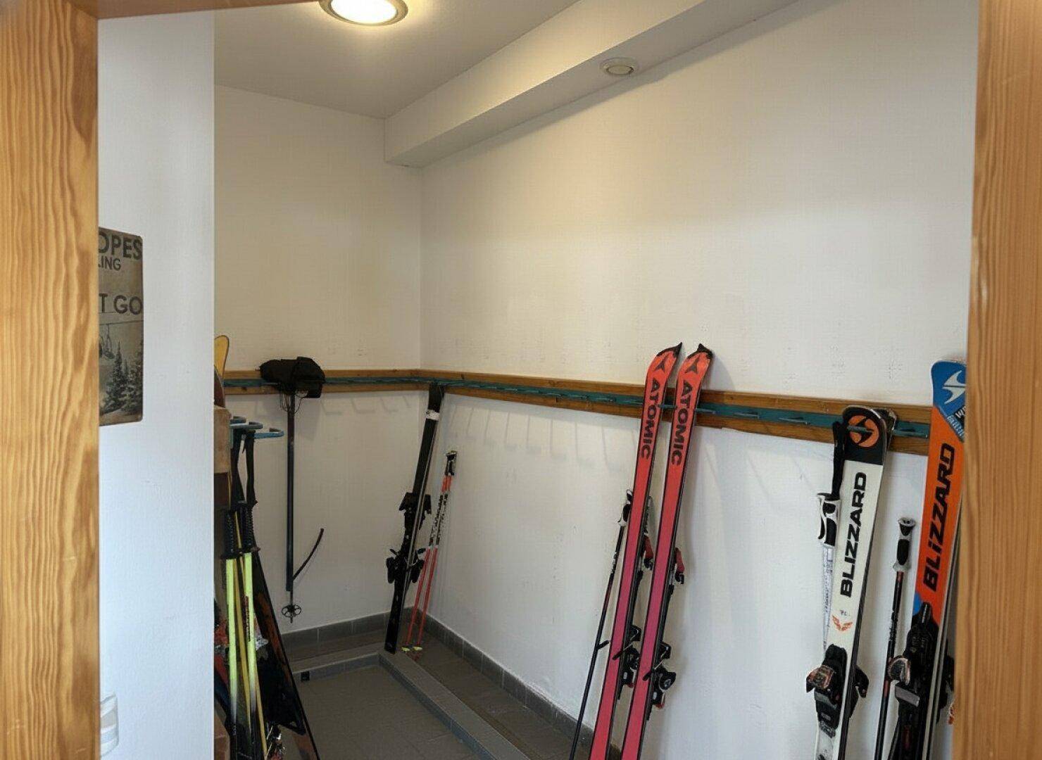 Praktischer Skiraum mit Halterungen für Skier und Ausrüstung.