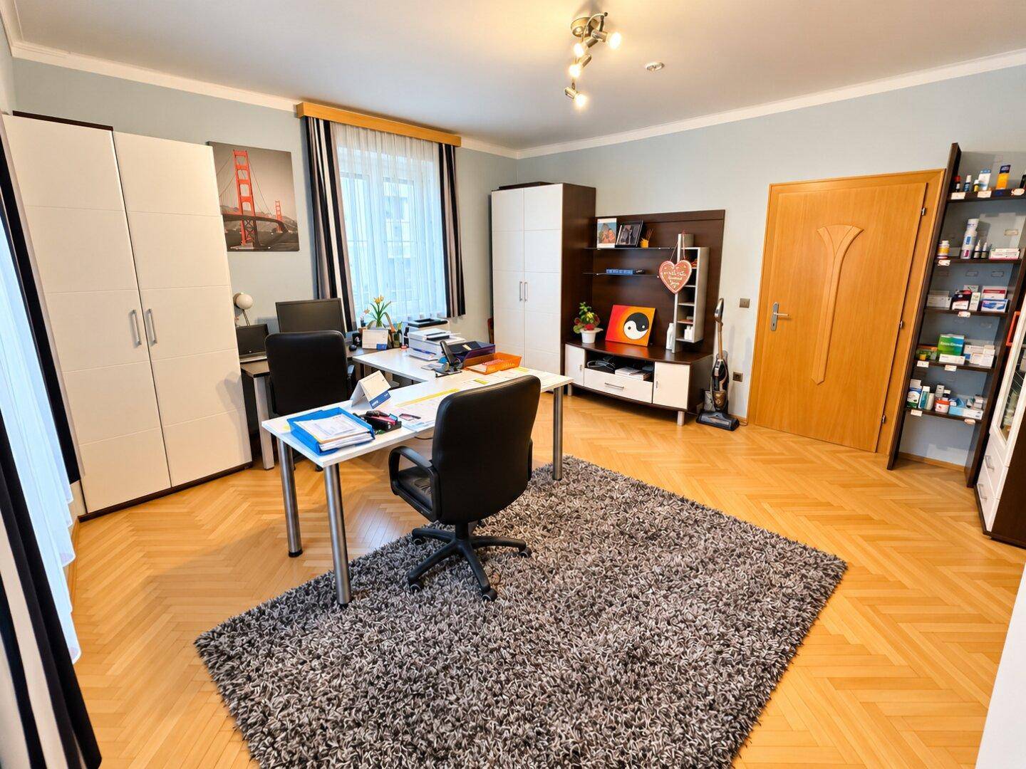 Funktionales Büro mit zwei Arbeitsplätzen, Teppich und Holzparkettboden.