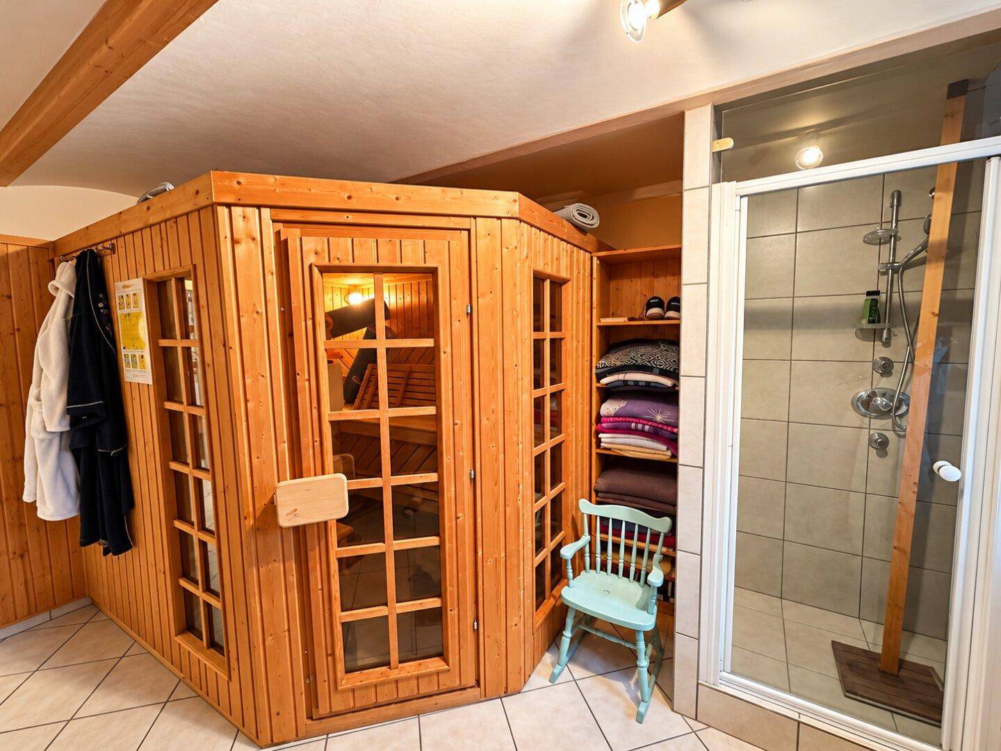 Privater Wellnessbereich mit Holzsauna und separater Dusche.