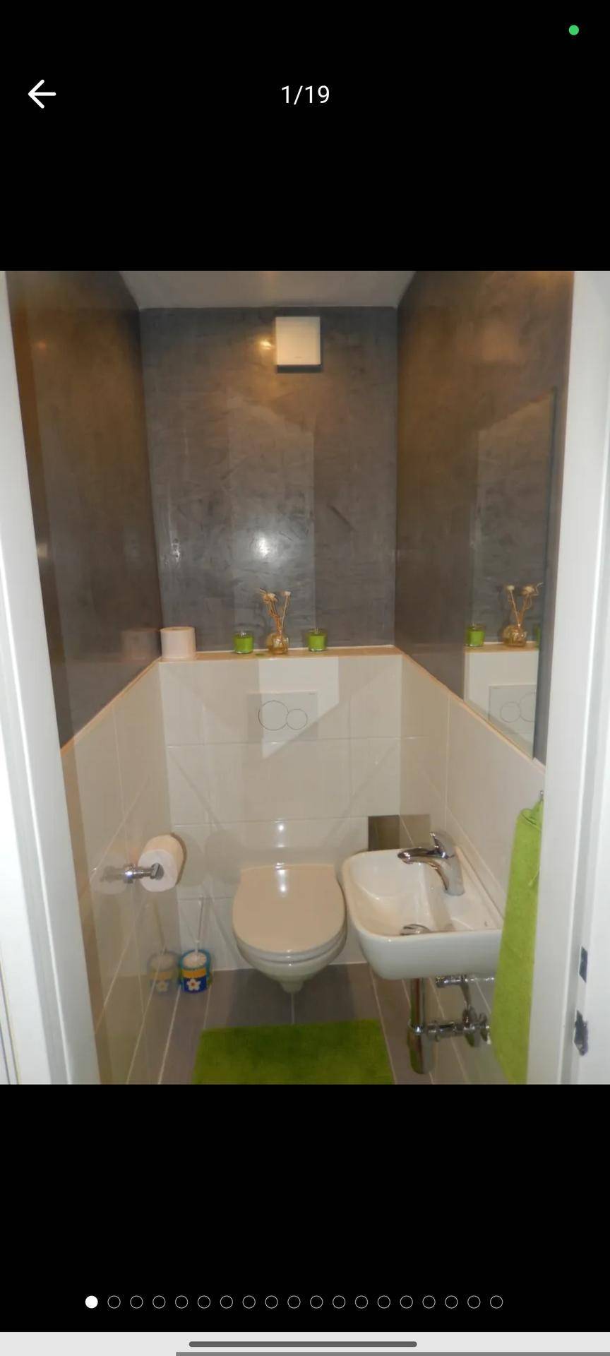 Modernes Gäste-WC mit wandhängender Toilette und kleinem Waschbecken in Grau und Weiß.